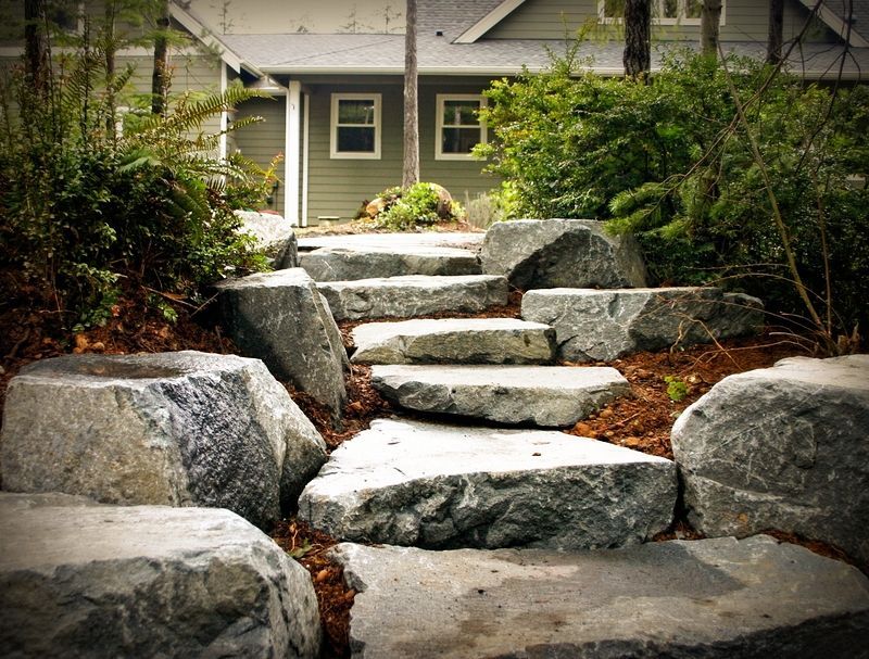 A stone walkway leading to a house in the woods