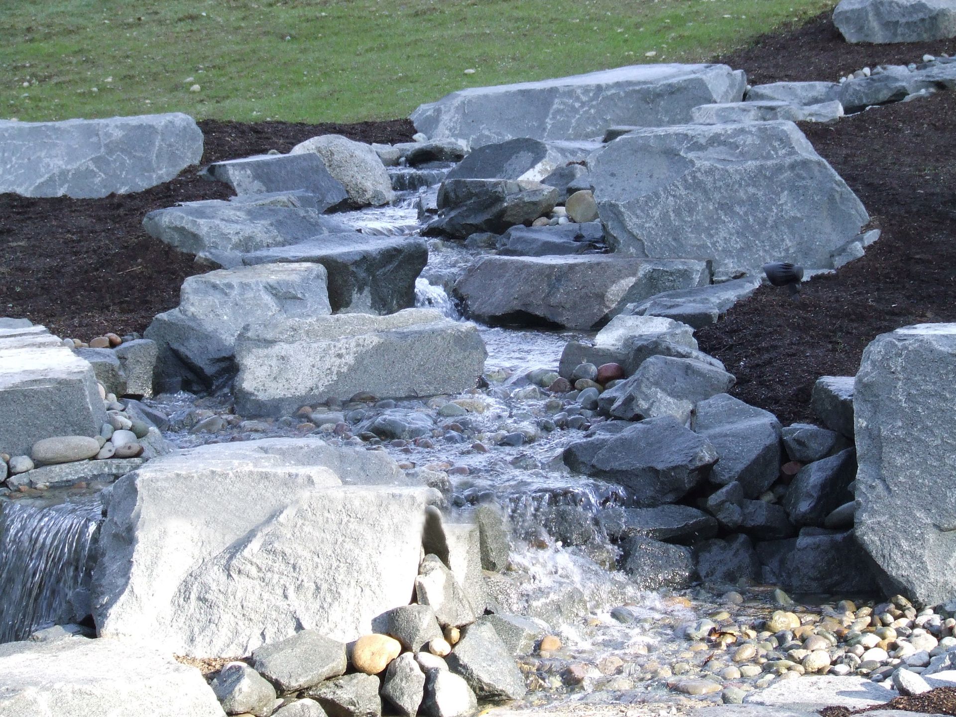 A stream of water flowing through a pile of rocks