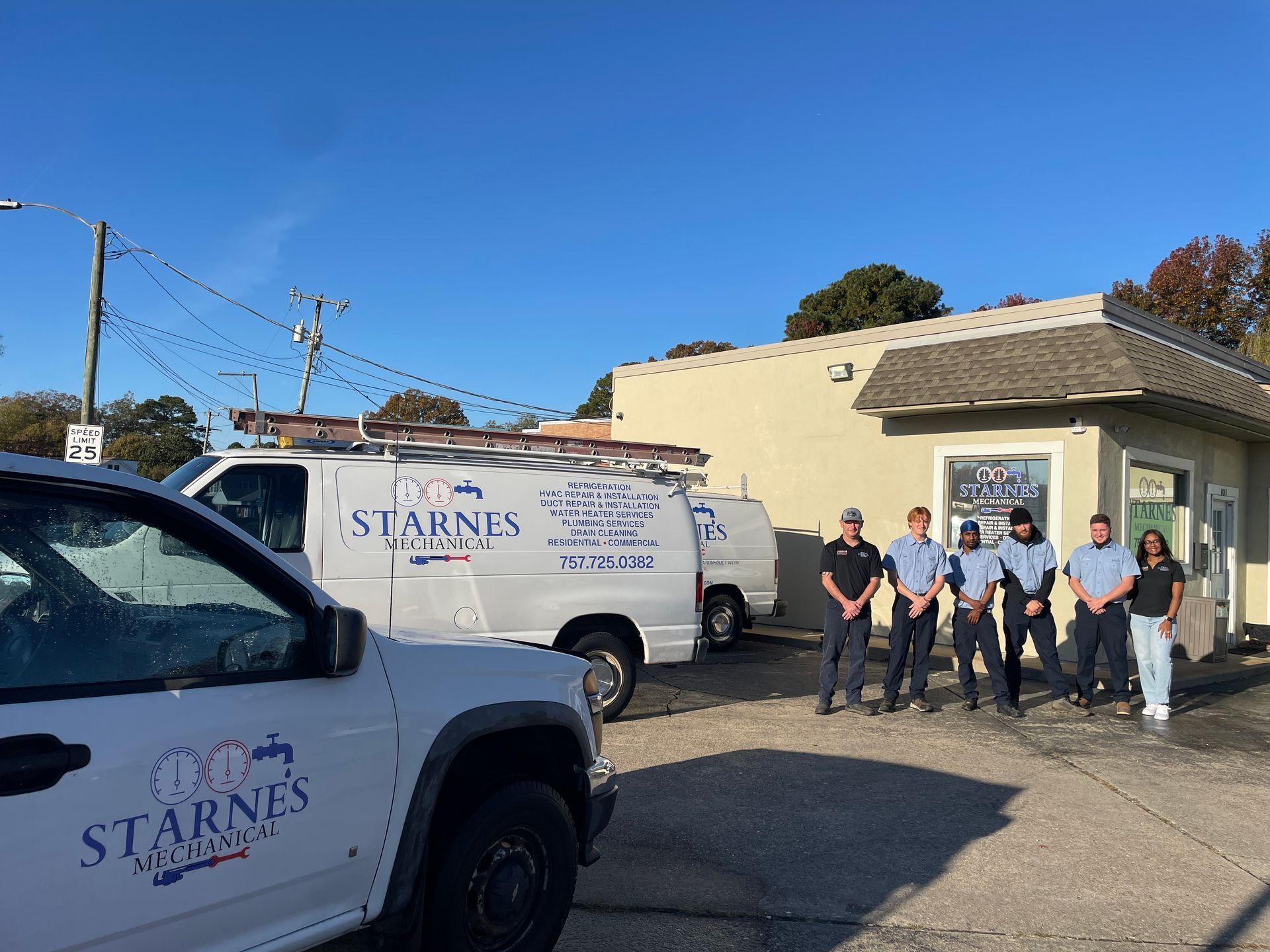 White vans and crew of plumbers in front of Starne's Plumbing business.