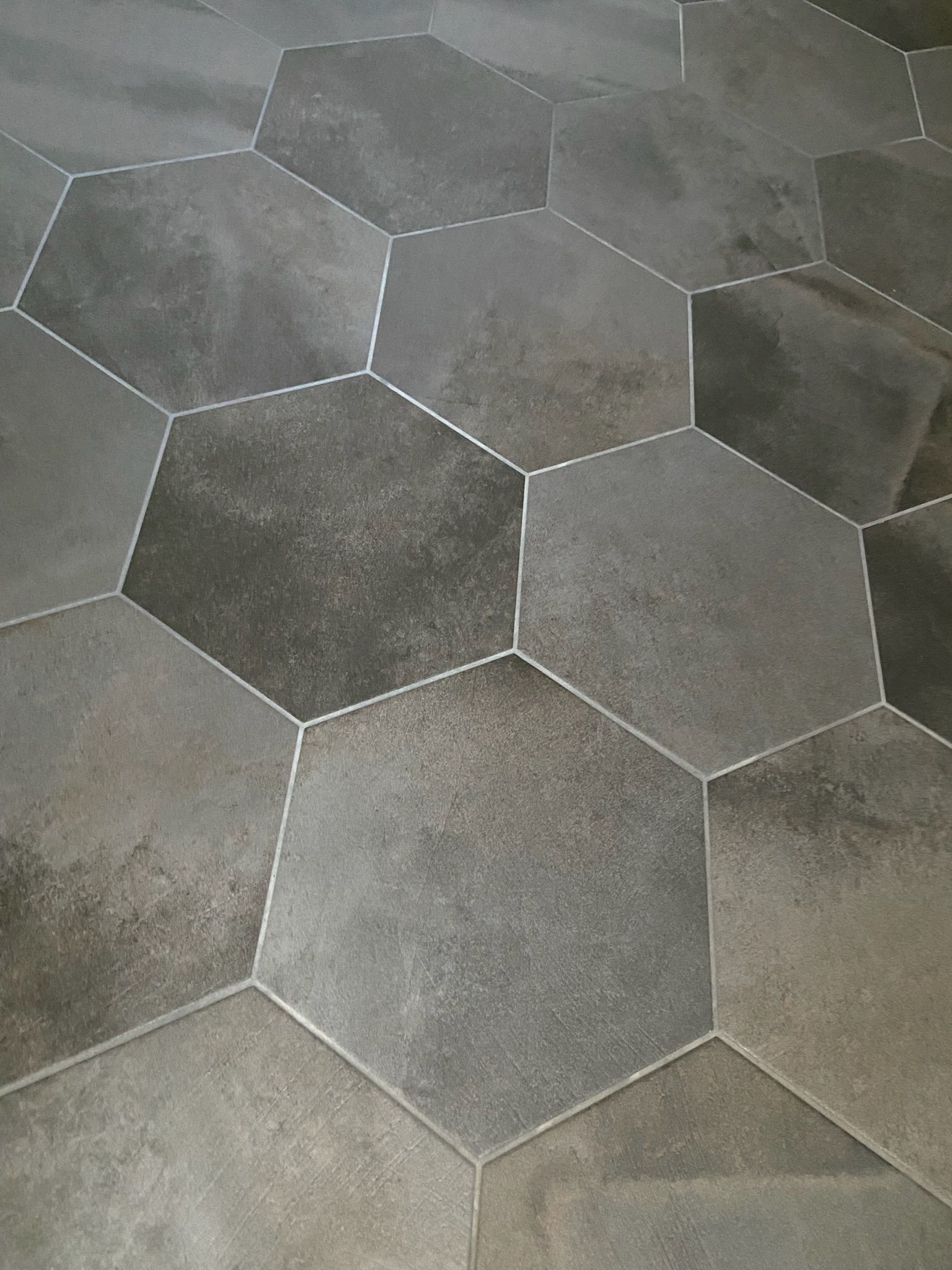 Hexagonal gray floor tiles with white grout lines.