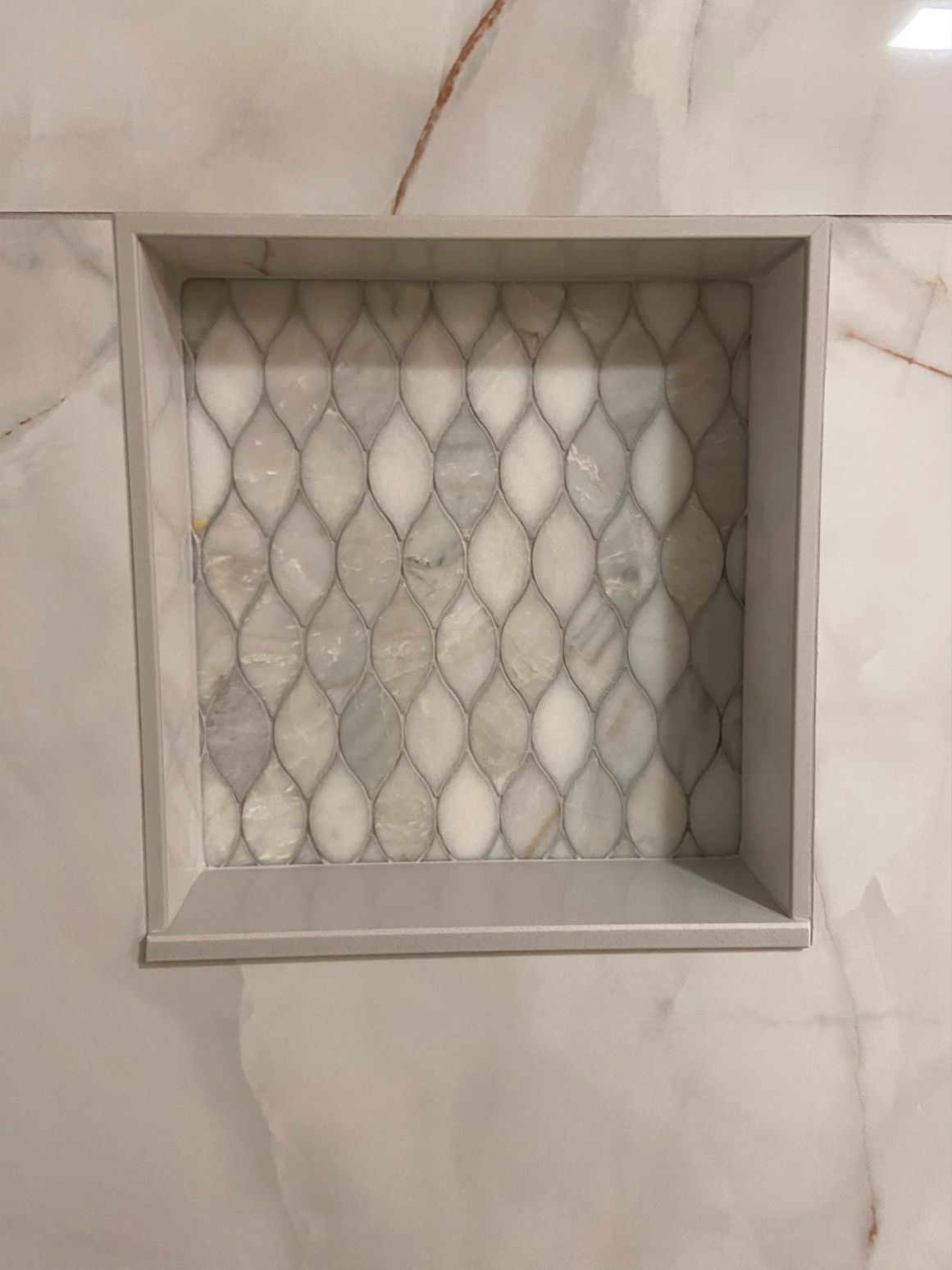 White recessed wall niche with a diamond-pattern mesh backing.