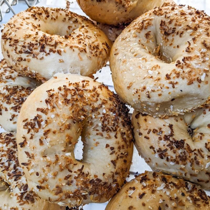 A bunch of bagels with sesame seeds on them