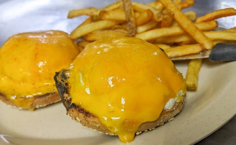 A plate of hamburgers and french fries on a table.