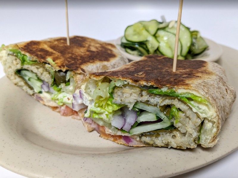 A close up of a sandwich on a plate with toothpicks in it.