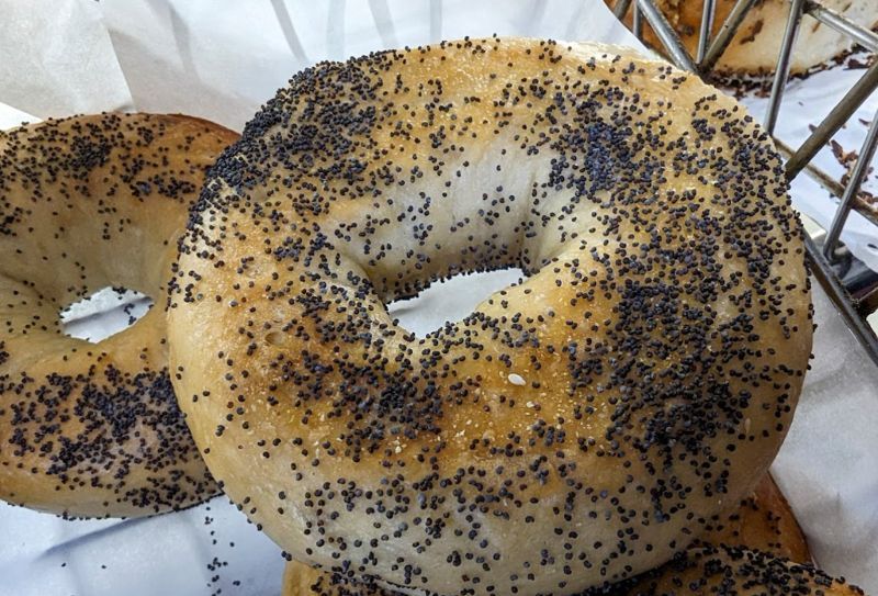 A close up of a bagel with poppy seeds on it