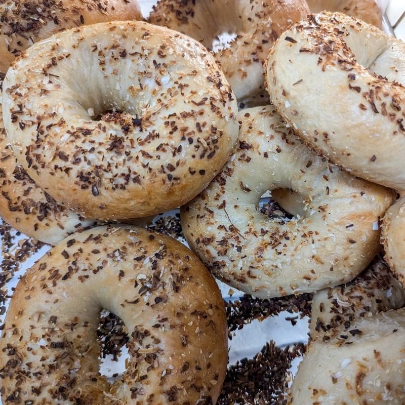 A bunch of bagels with sesame seeds on them