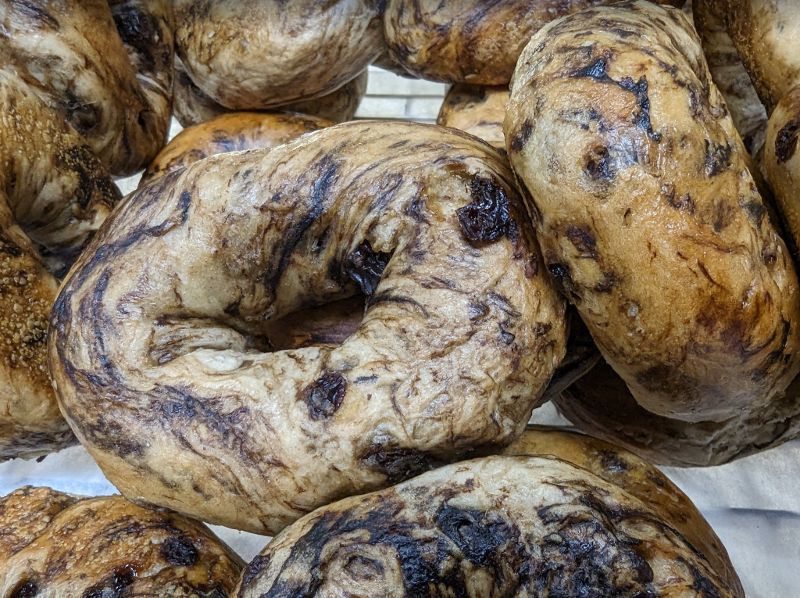 A bunch of bagels are sitting on top of each other on a table.