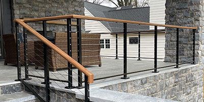 A patio with a wooden railing and stairs leading up to it.