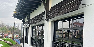 A white building with a lot of windows and a roof.