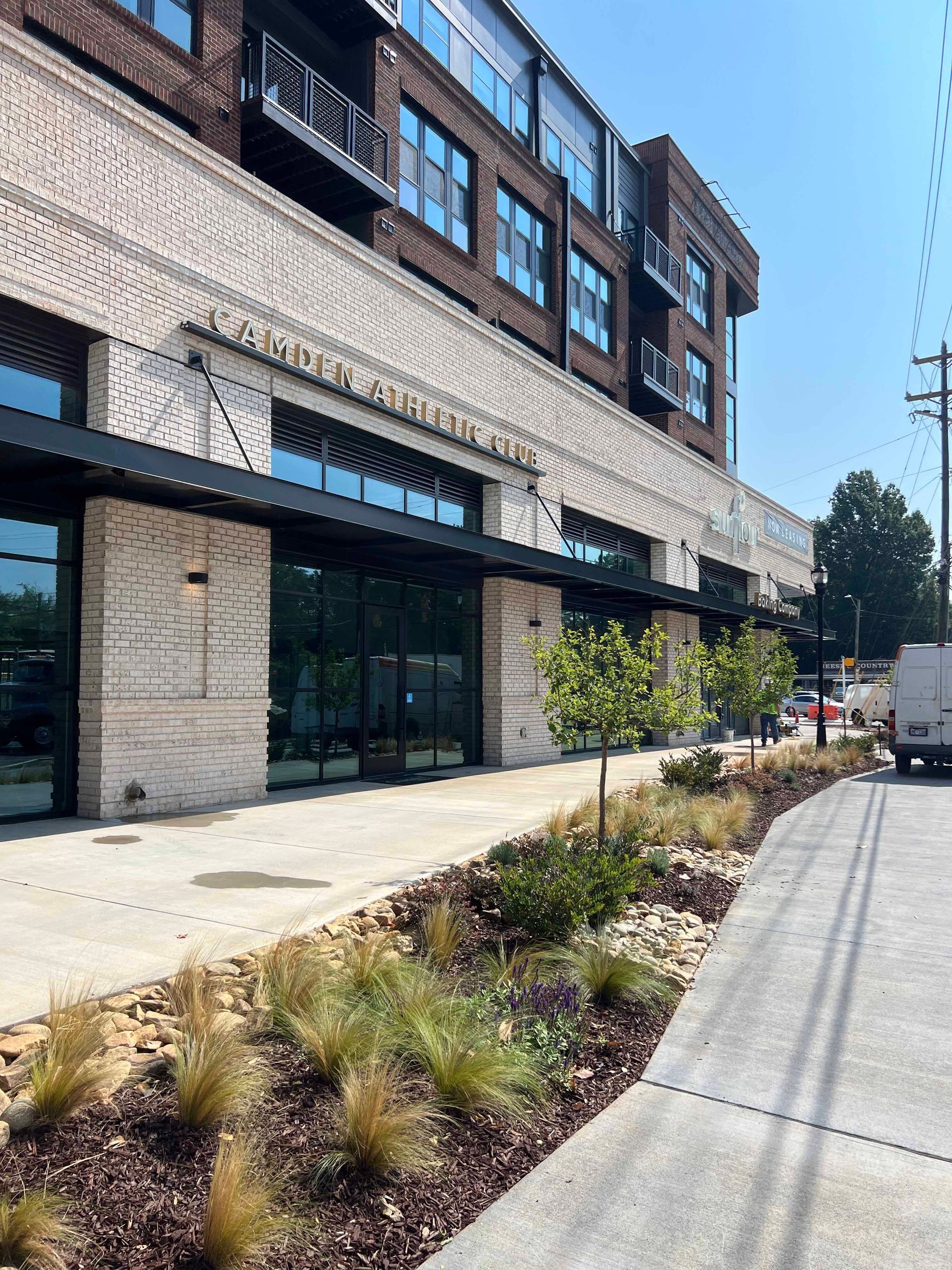 A large building with a lot of windows and a sidewalk in front of it.