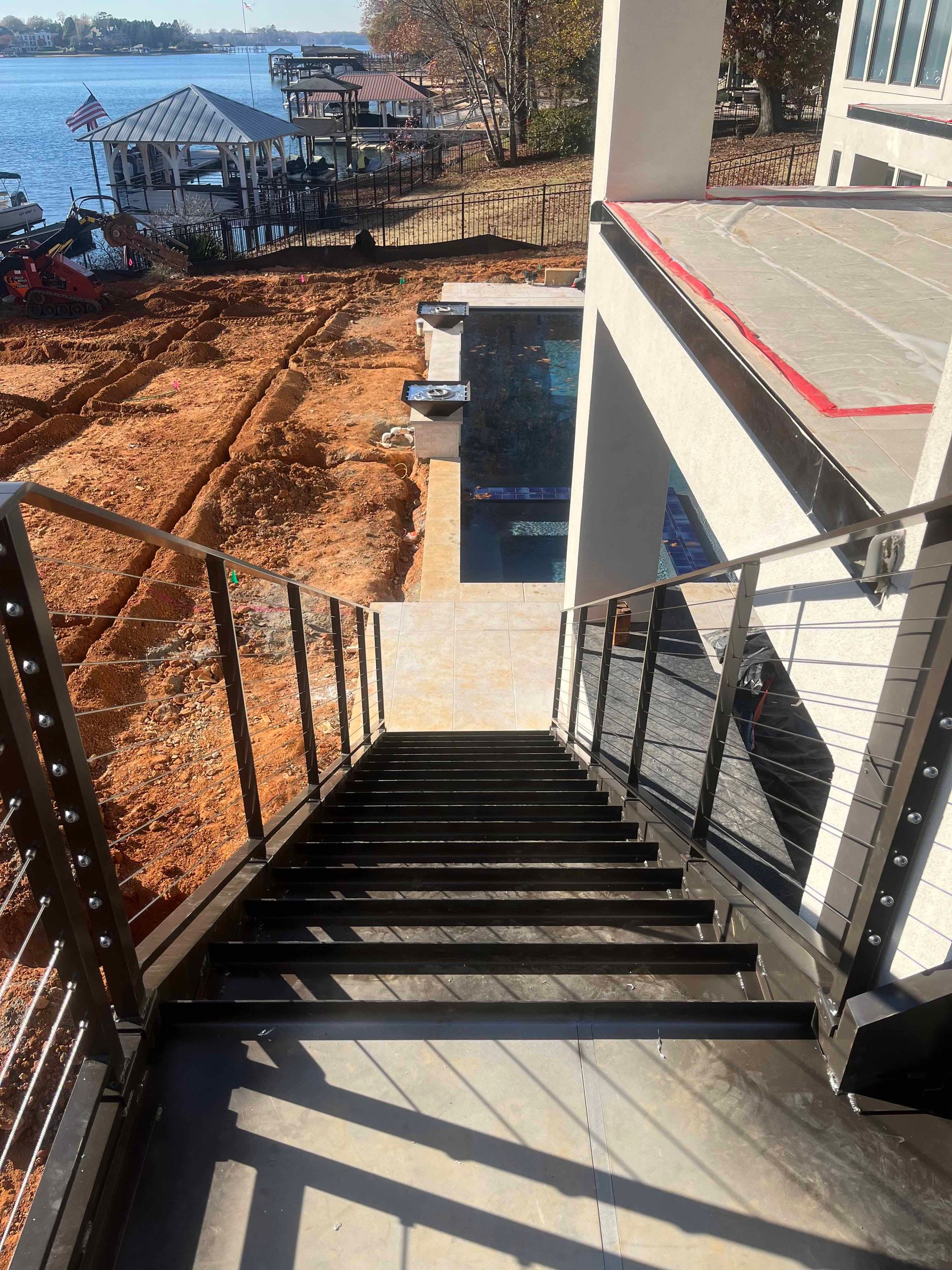 A set of stairs leading up to a deck with a view of a lake.