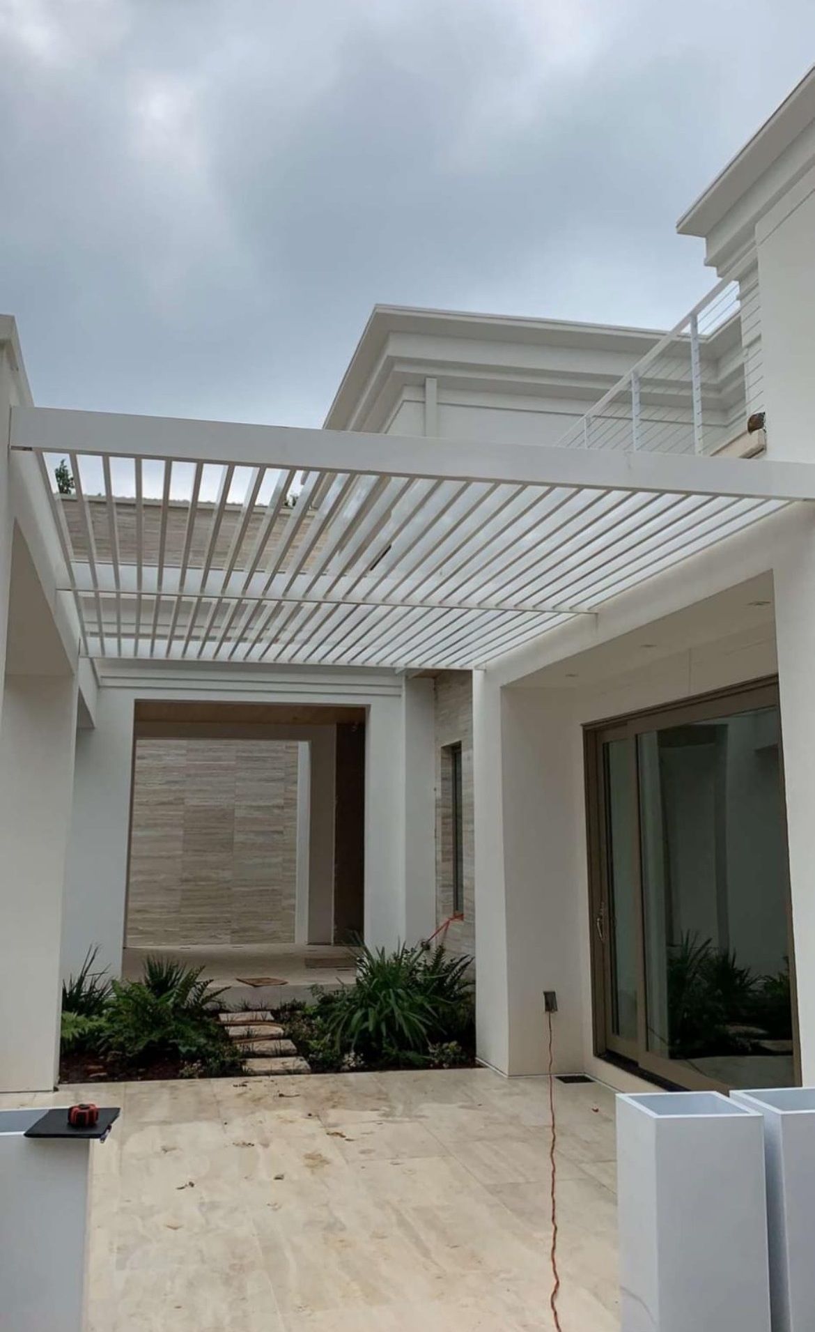 A white house with a pergola on top of it.