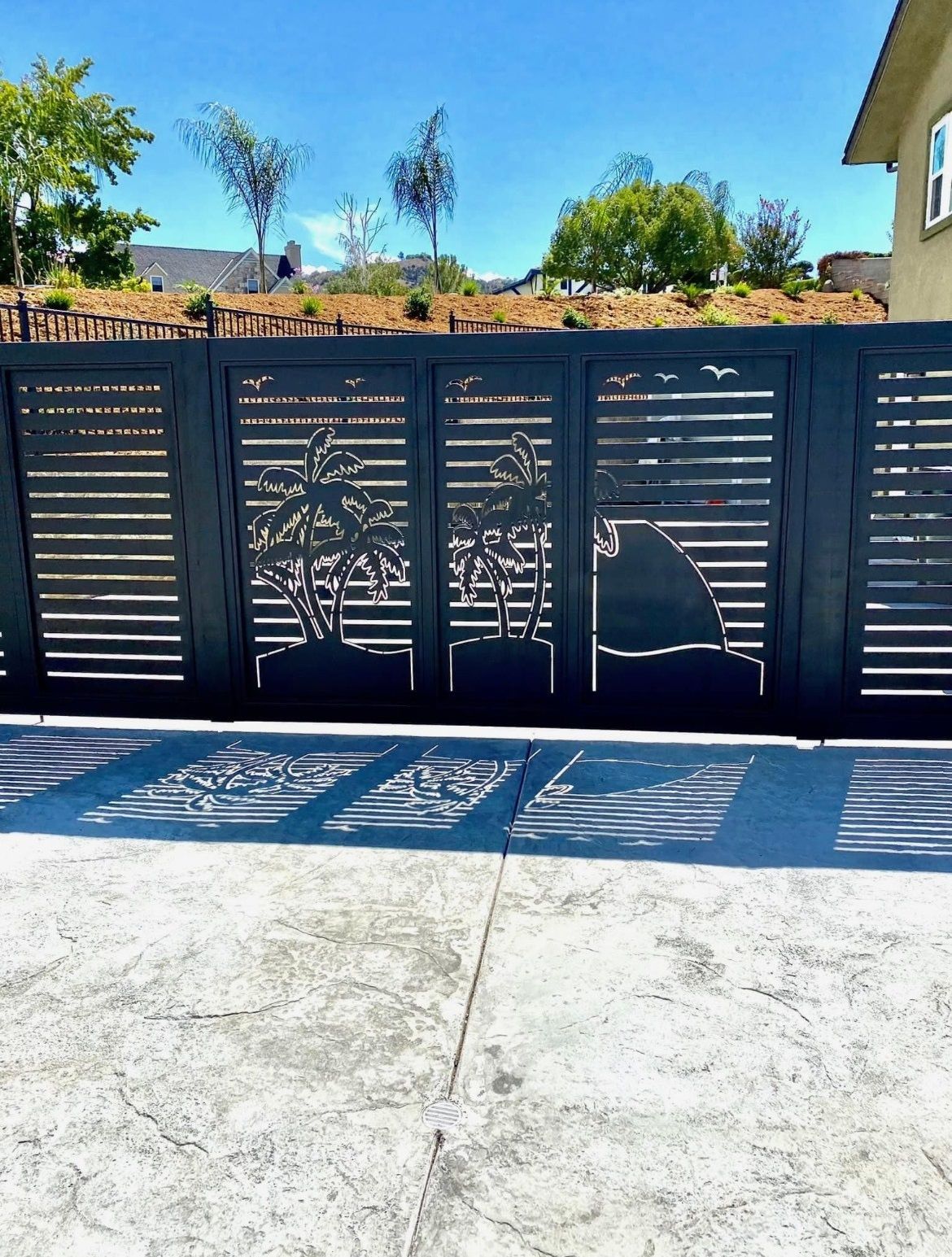 A black gate with a silhouette of a mountain on it
