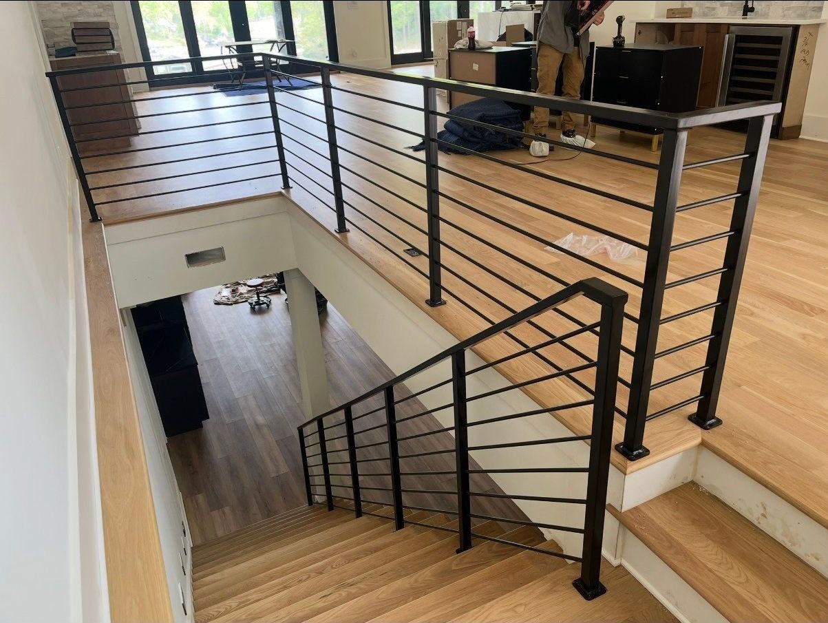 A staircase with a black railing and wooden steps in a house.