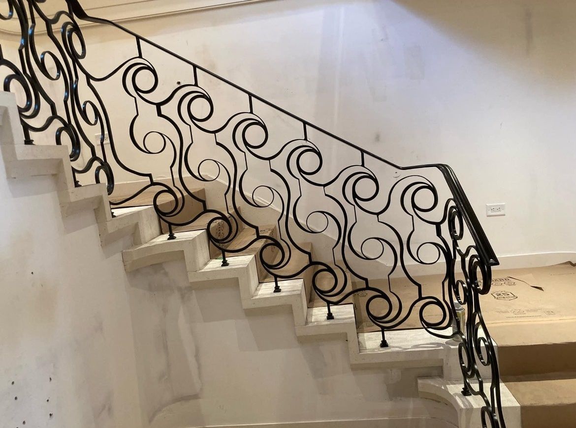 There is a wrought iron railing on the stairs.