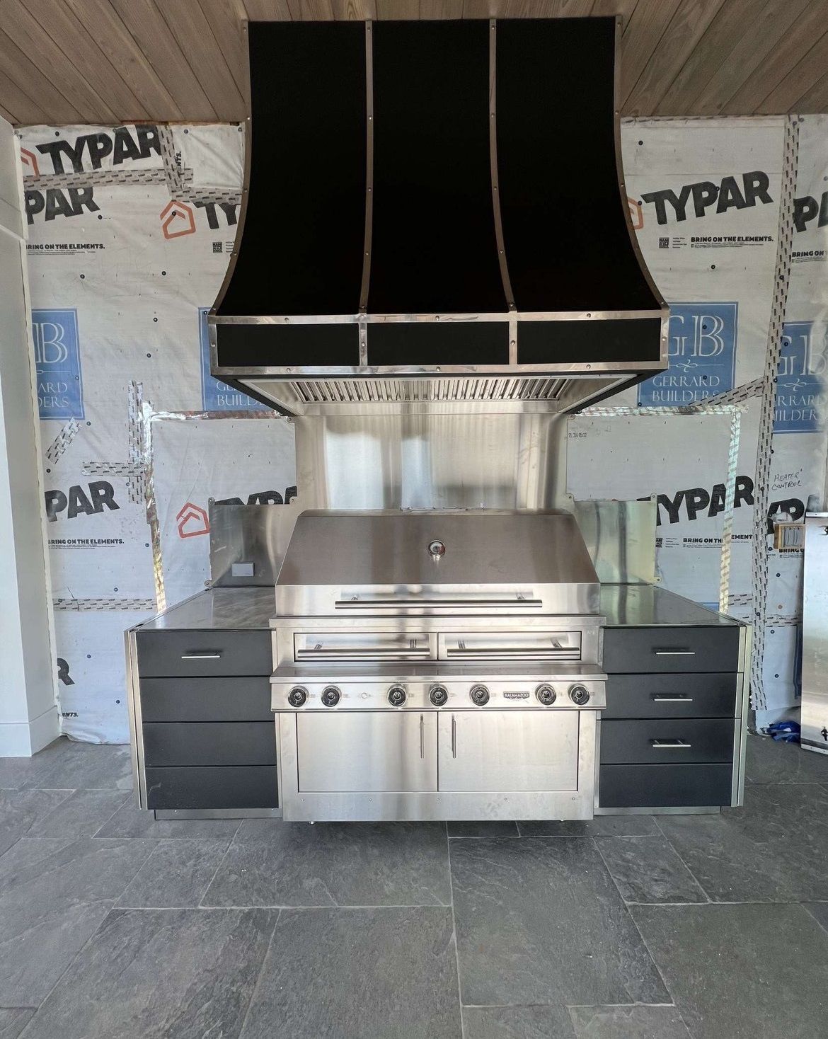 A stainless steel grill with a black hood in a kitchen