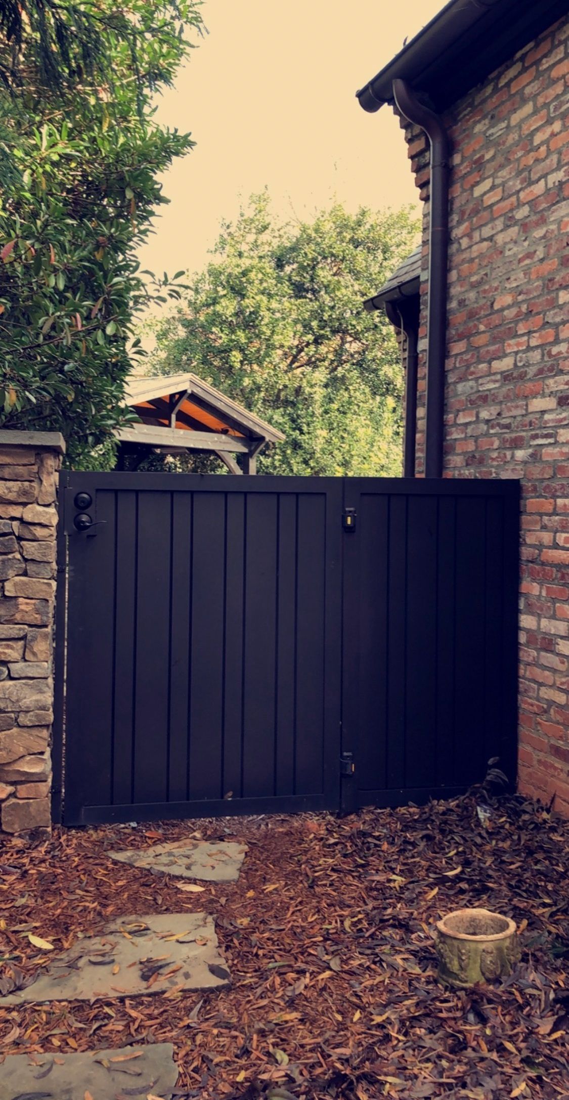 A black gate is sitting in front of a brick building.