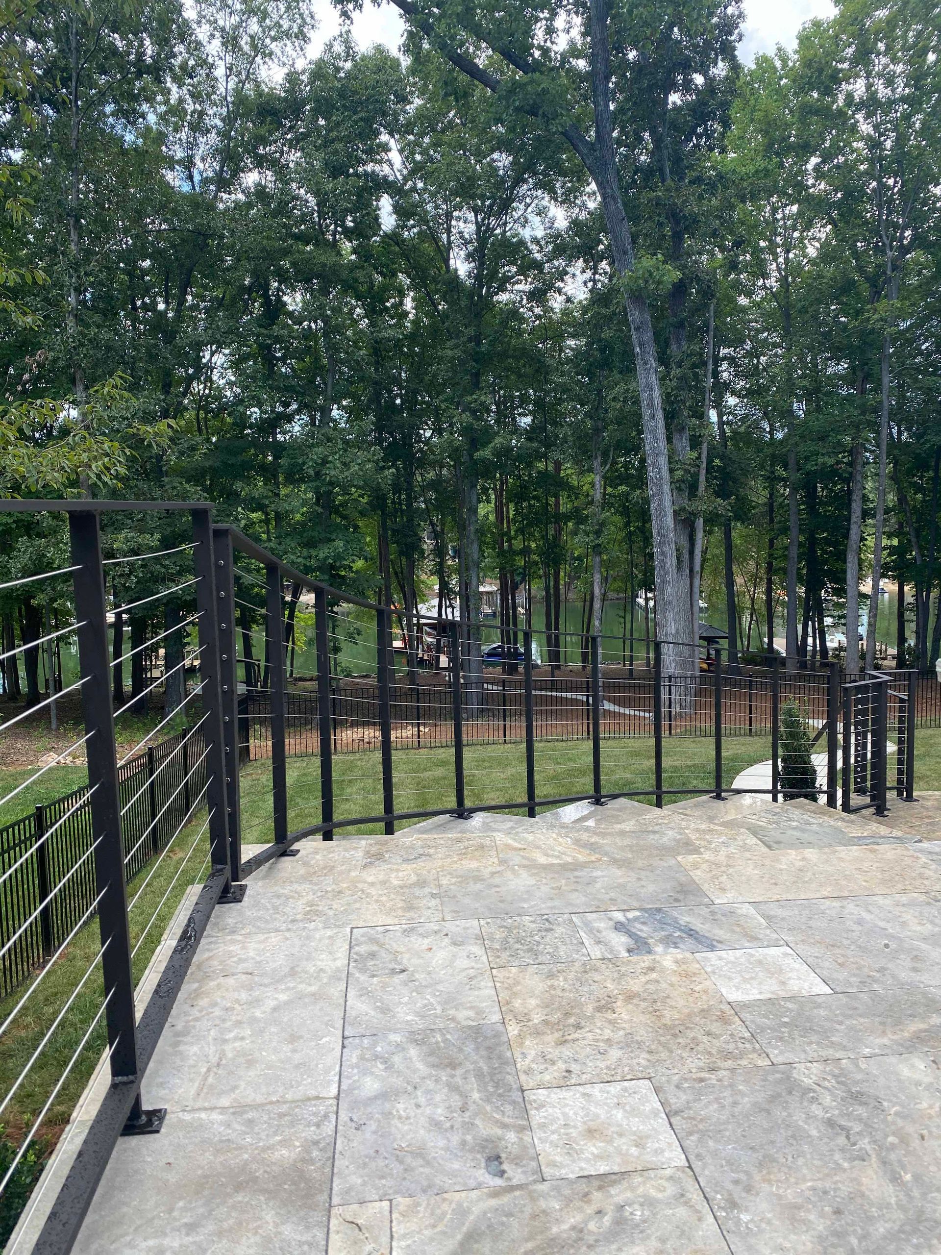 A patio with a fence and trees in the background.