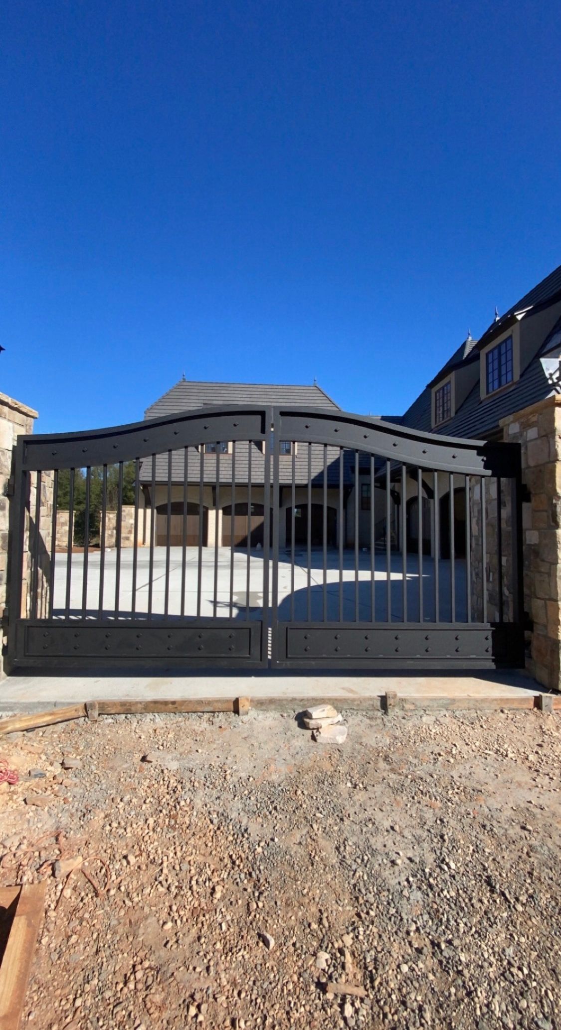 A black gate is sitting in front of a house.