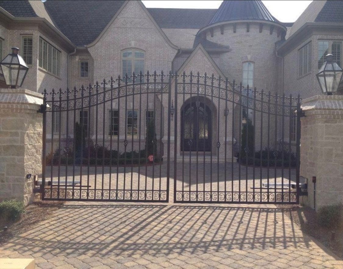A large house with a wrought iron gate in front of it