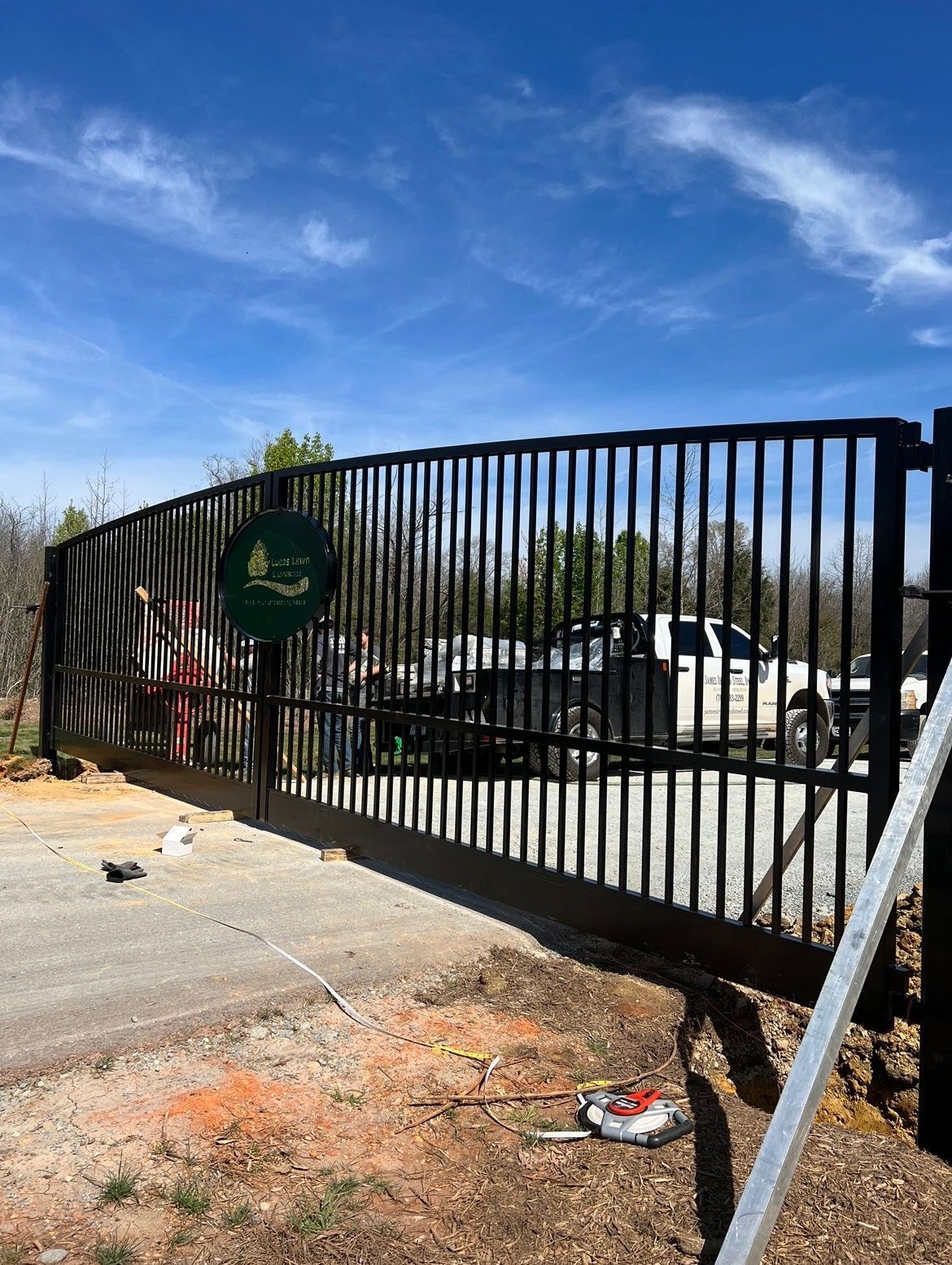 A sliding gate is being installed in a parking lot.