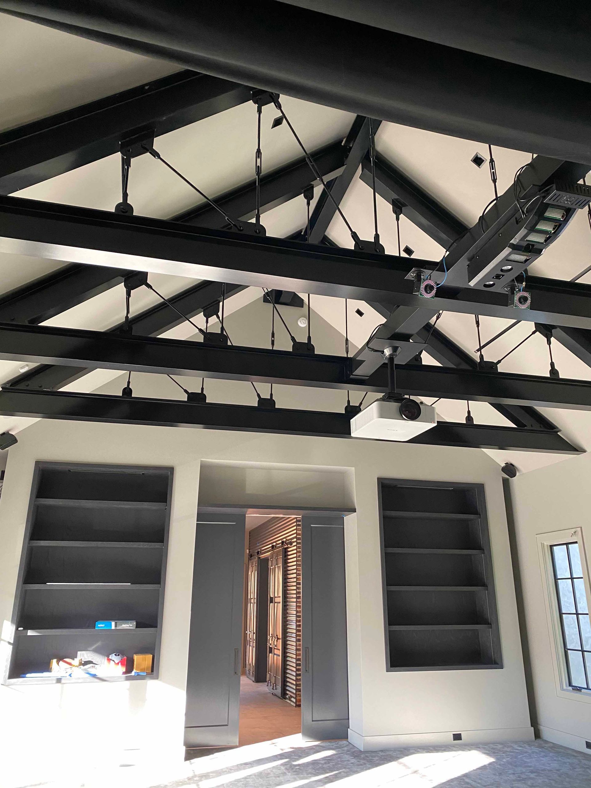 A room with a ceiling fan and shelves in it