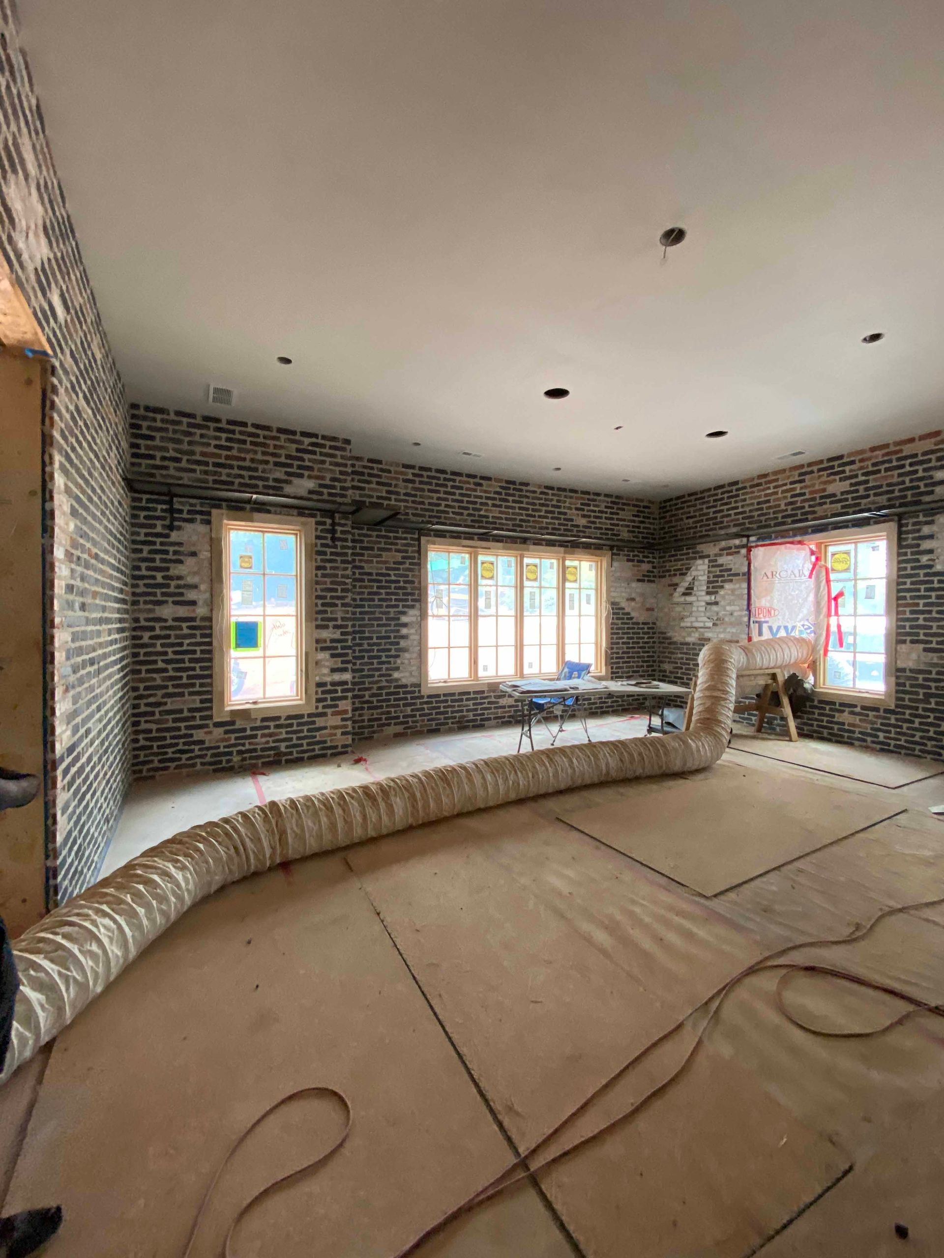 A large room with a lot of windows and a hose on the floor.