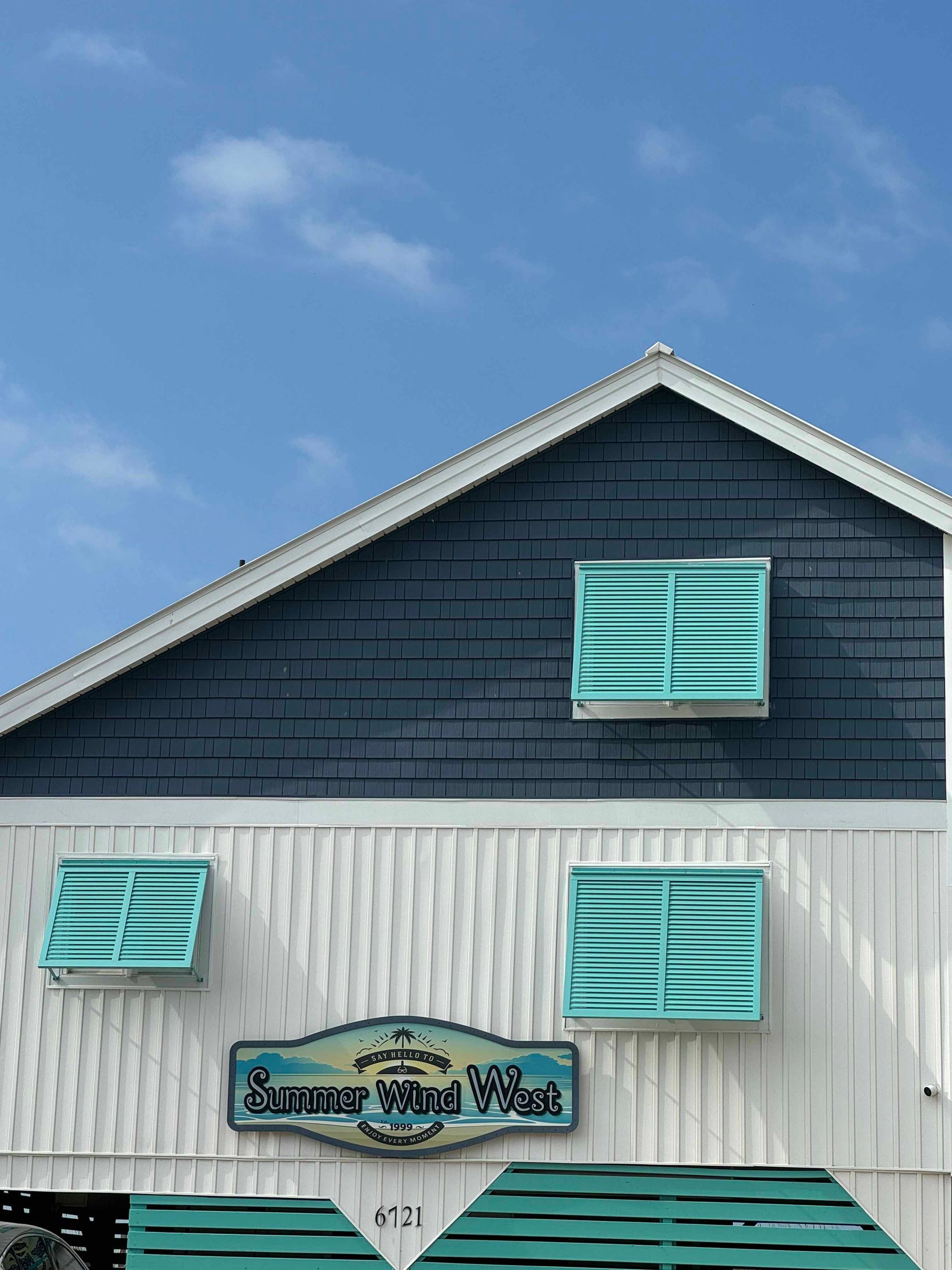 A blue and white building with a sign that says summer wind west