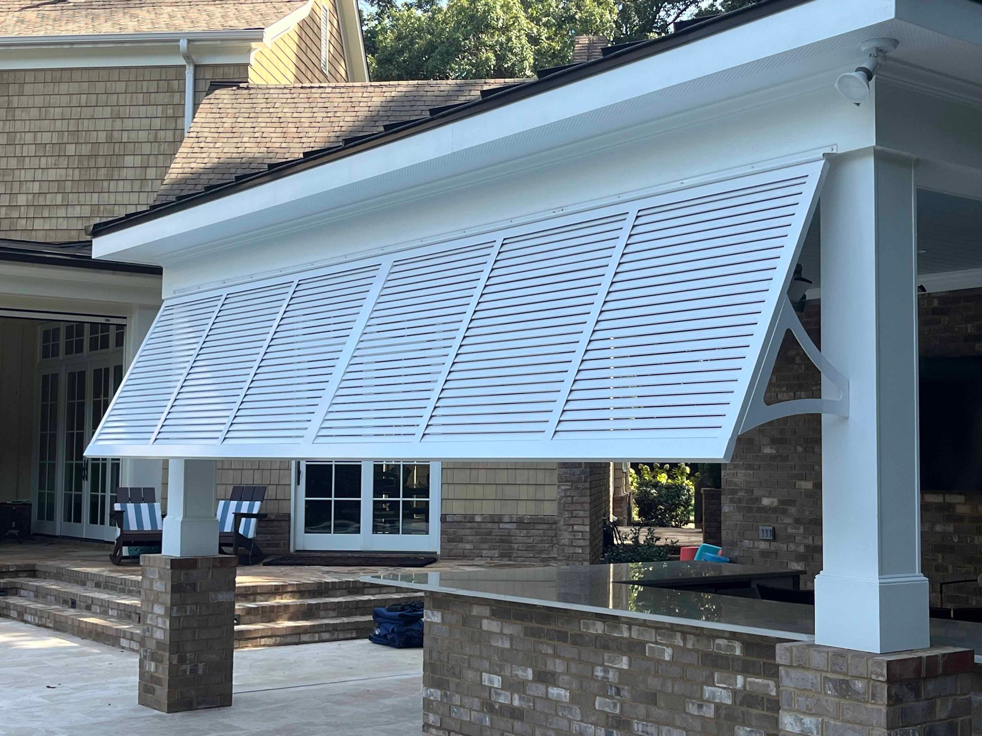 A white awning is hanging from the side of a house.