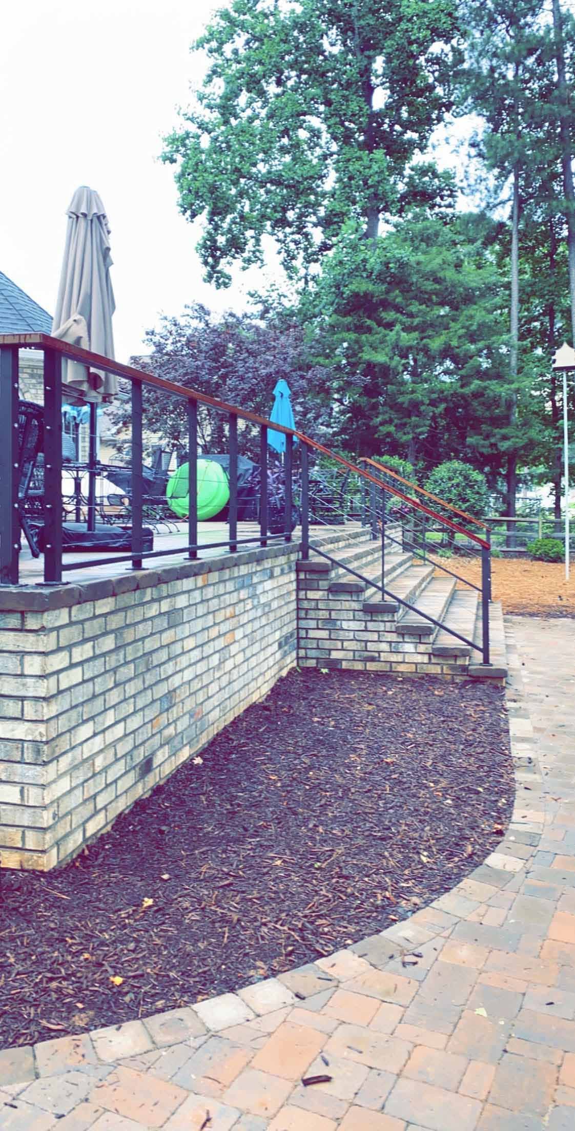 A brick wall with stairs leading up to it in a park.