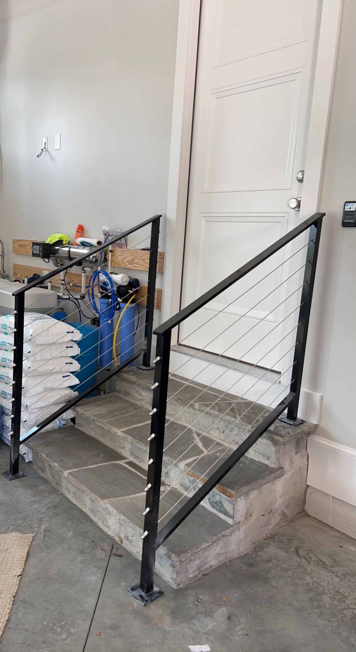 A staircase with a black railing is being built in a garage.