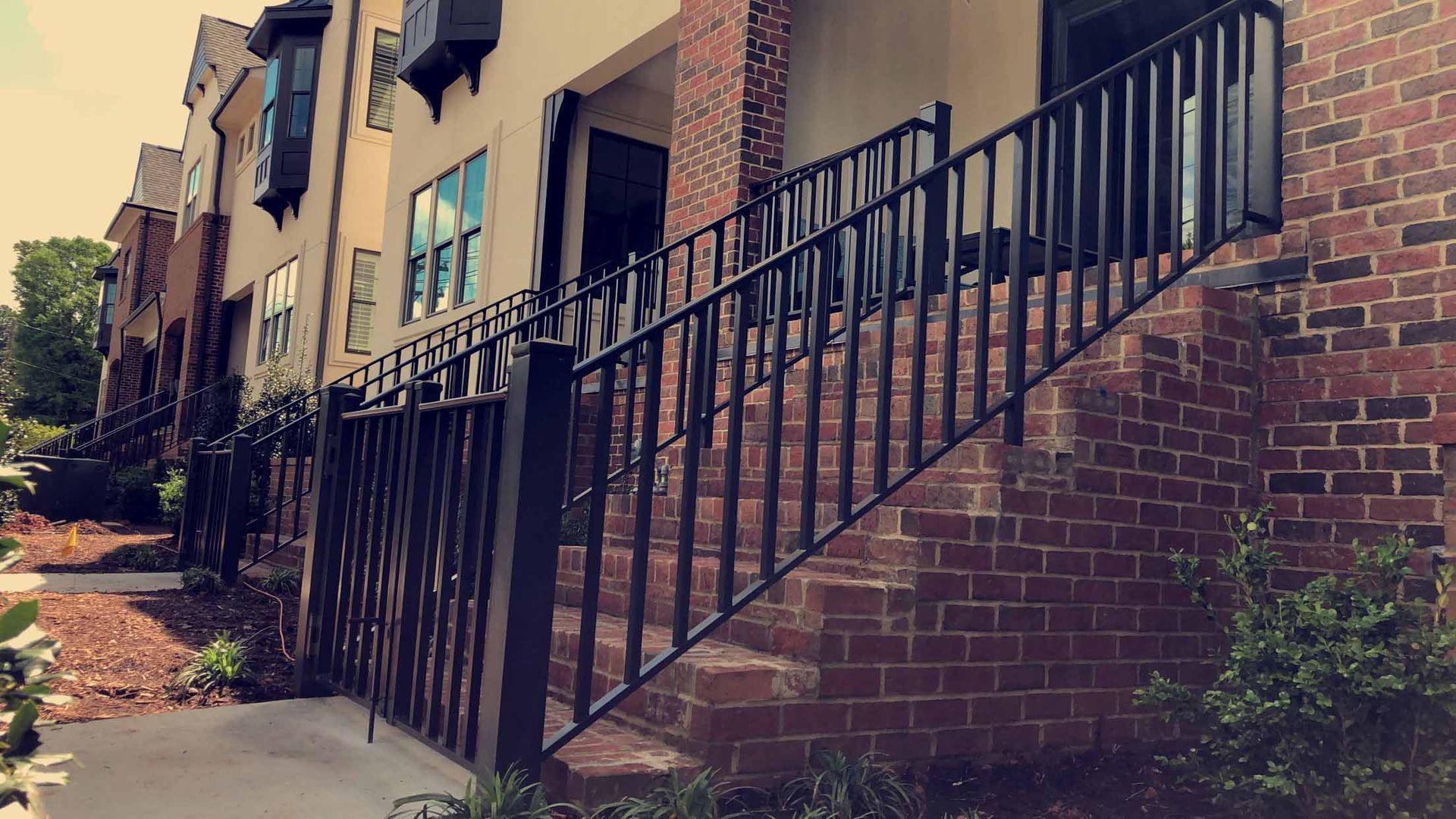 A brick building with stairs leading up to it and a metal railing.