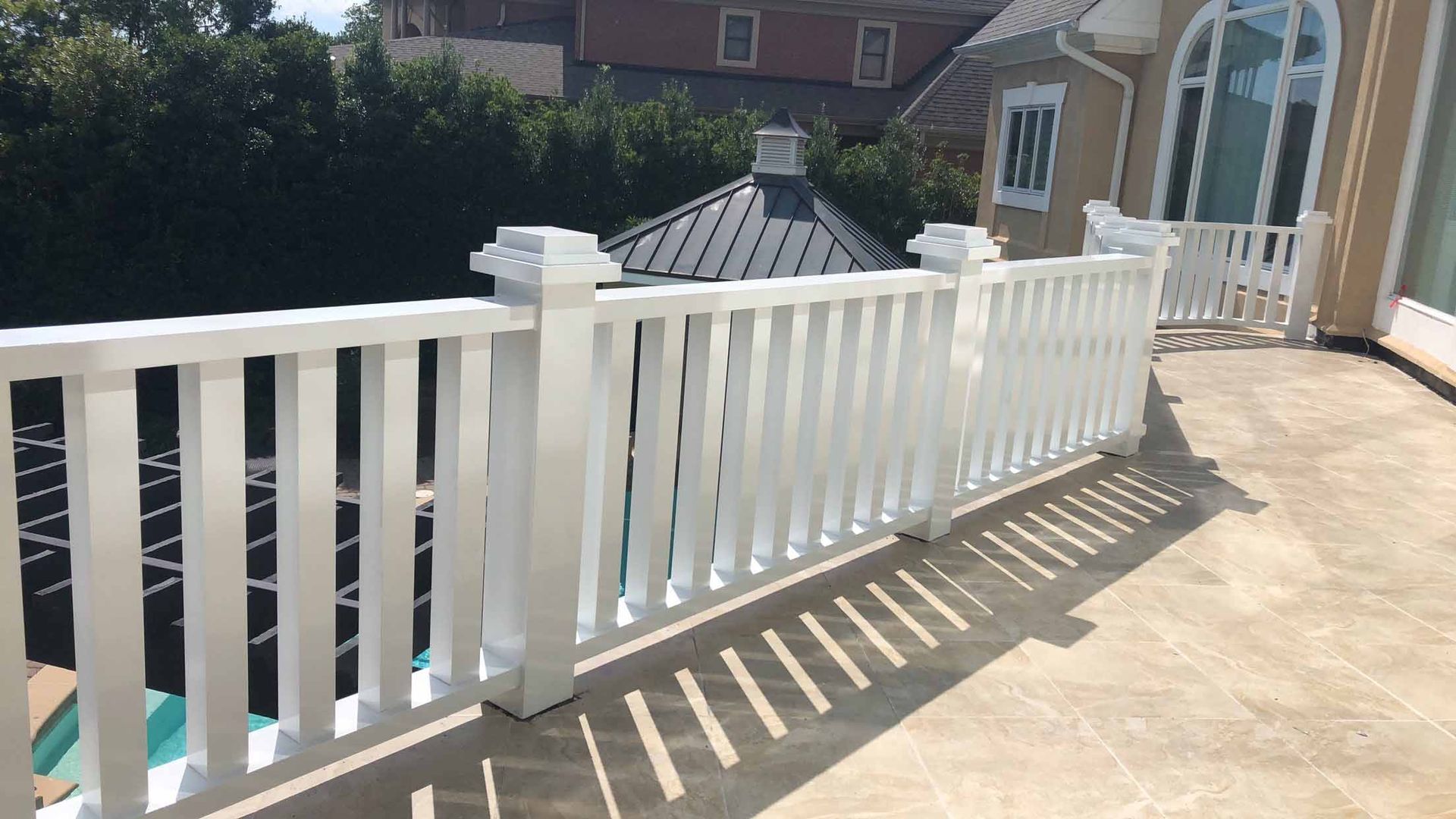 There is a white railing on the balcony of a house.