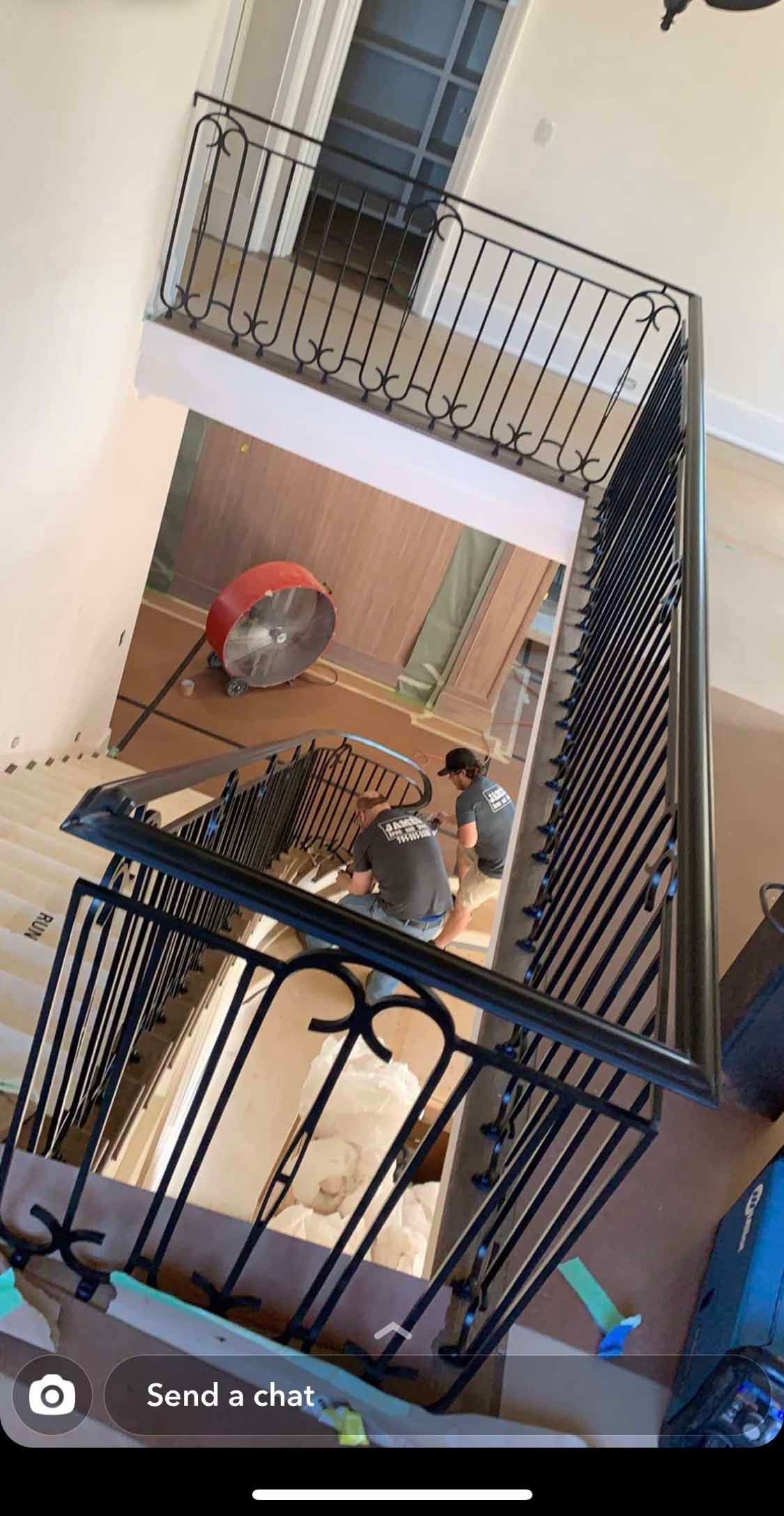 A group of people are working on a staircase in a house.