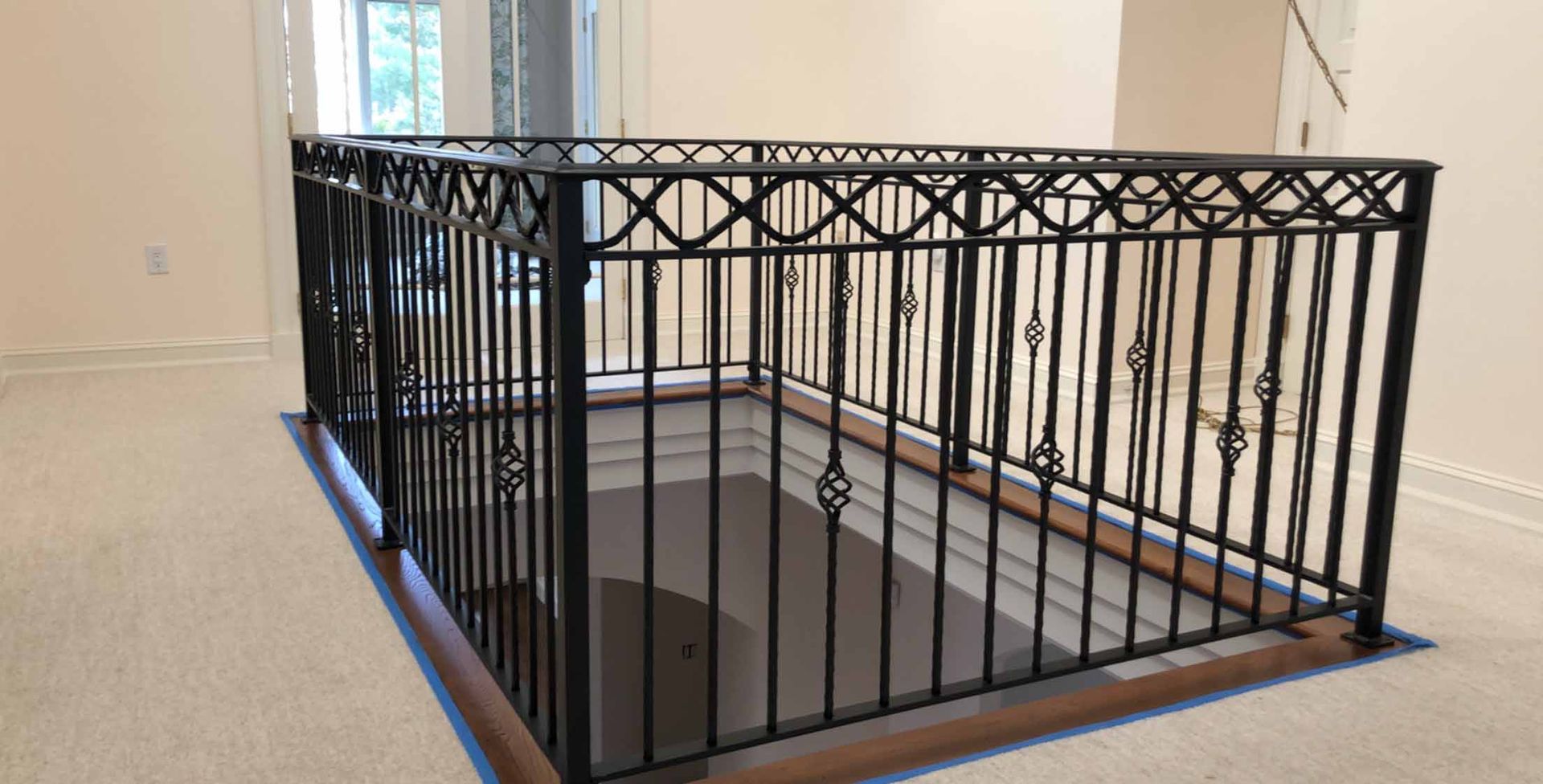 A wrought iron railing on a staircase in a house.