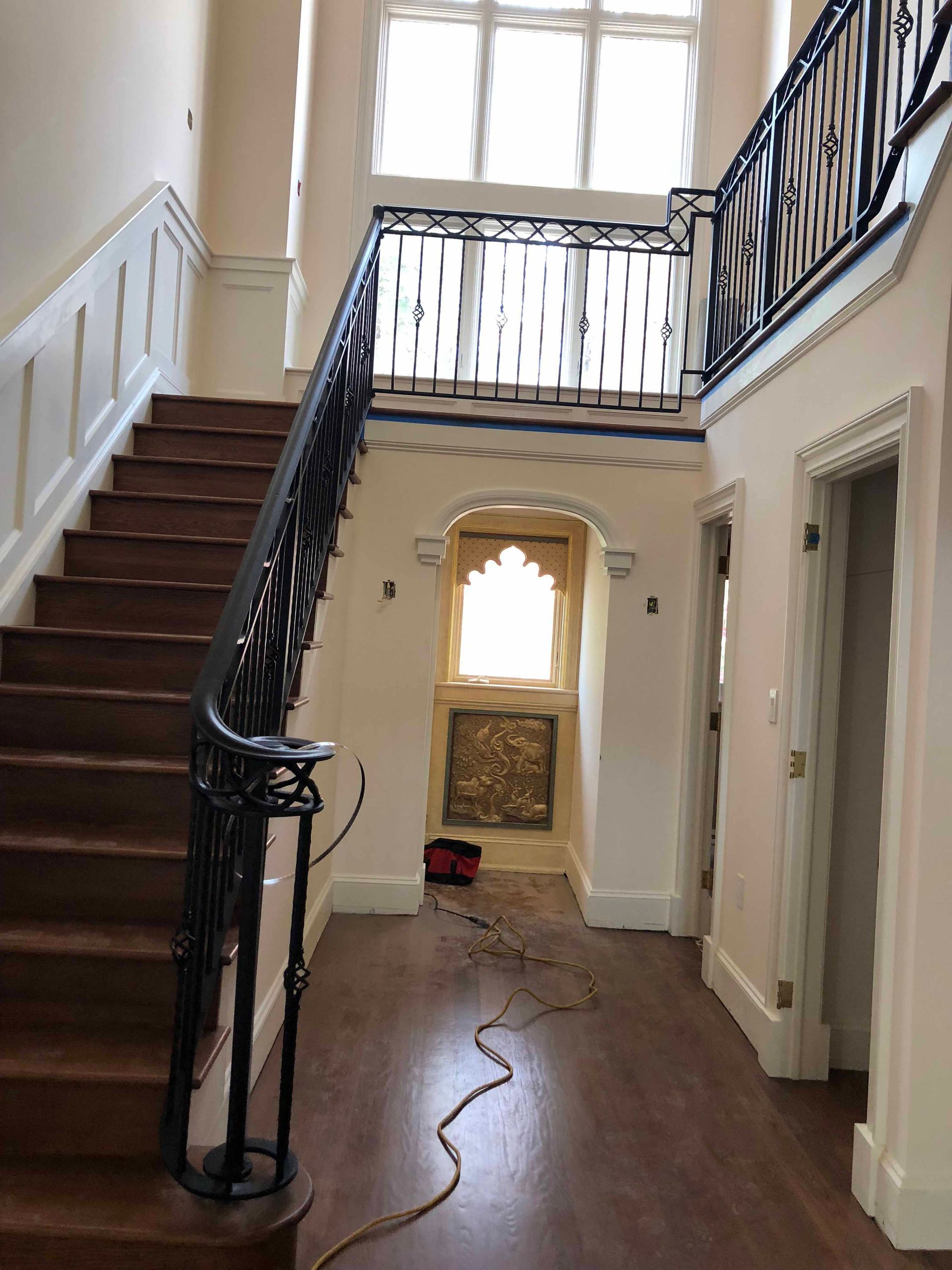 A hallway with stairs and a balcony in a house.