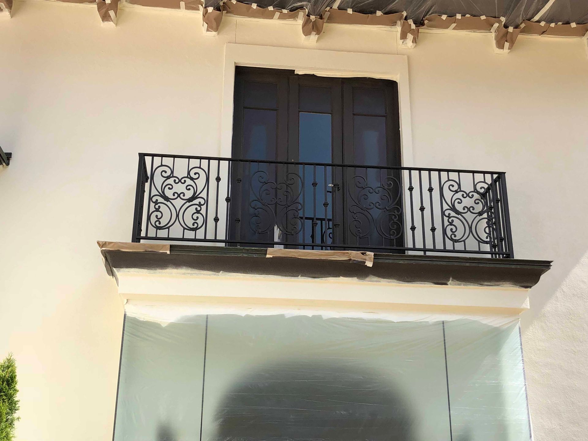 A balcony on the side of a building with a wrought iron railing