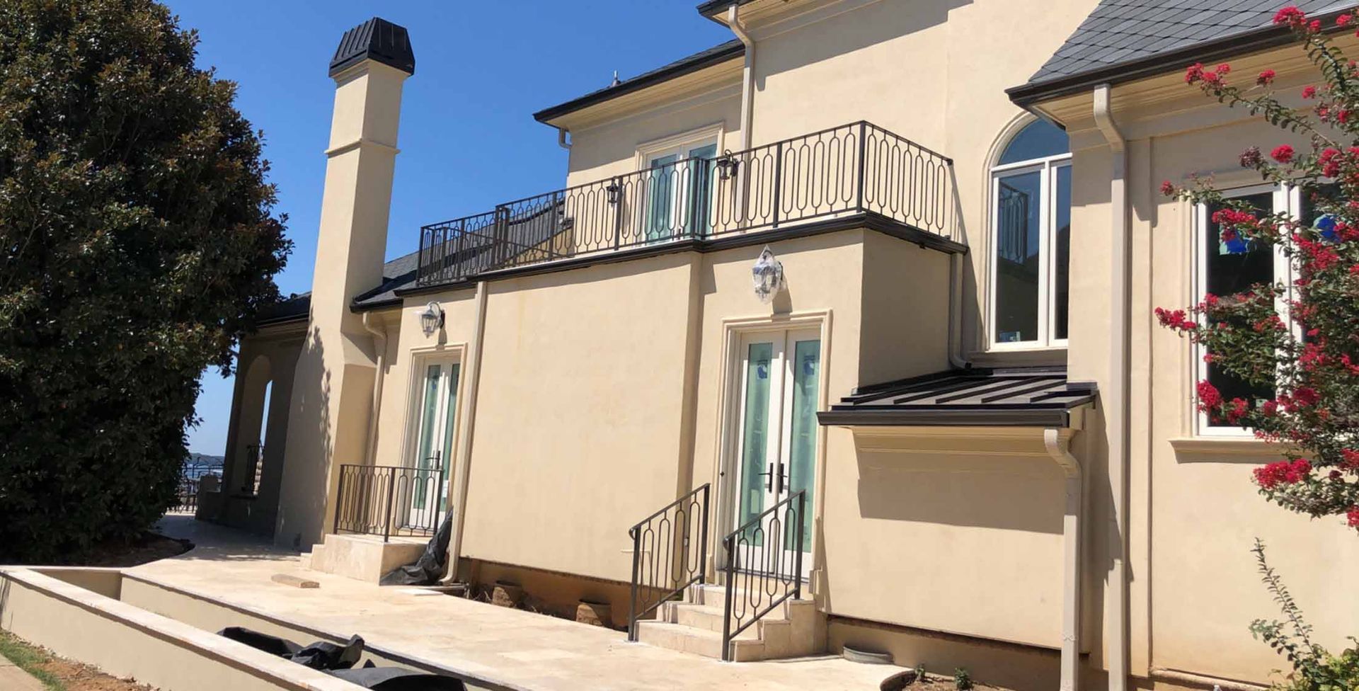 A large house with a balcony and stairs on the side of it.