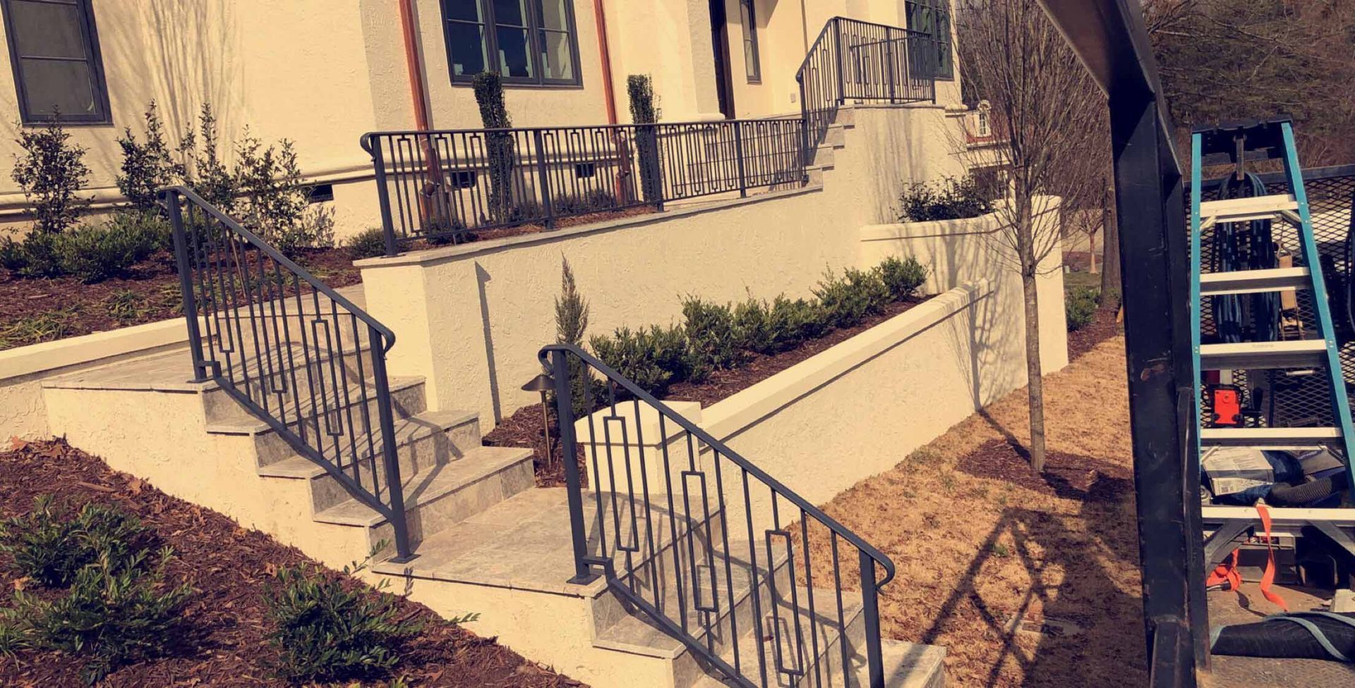 A white house with stairs and a ladder in front of it.
