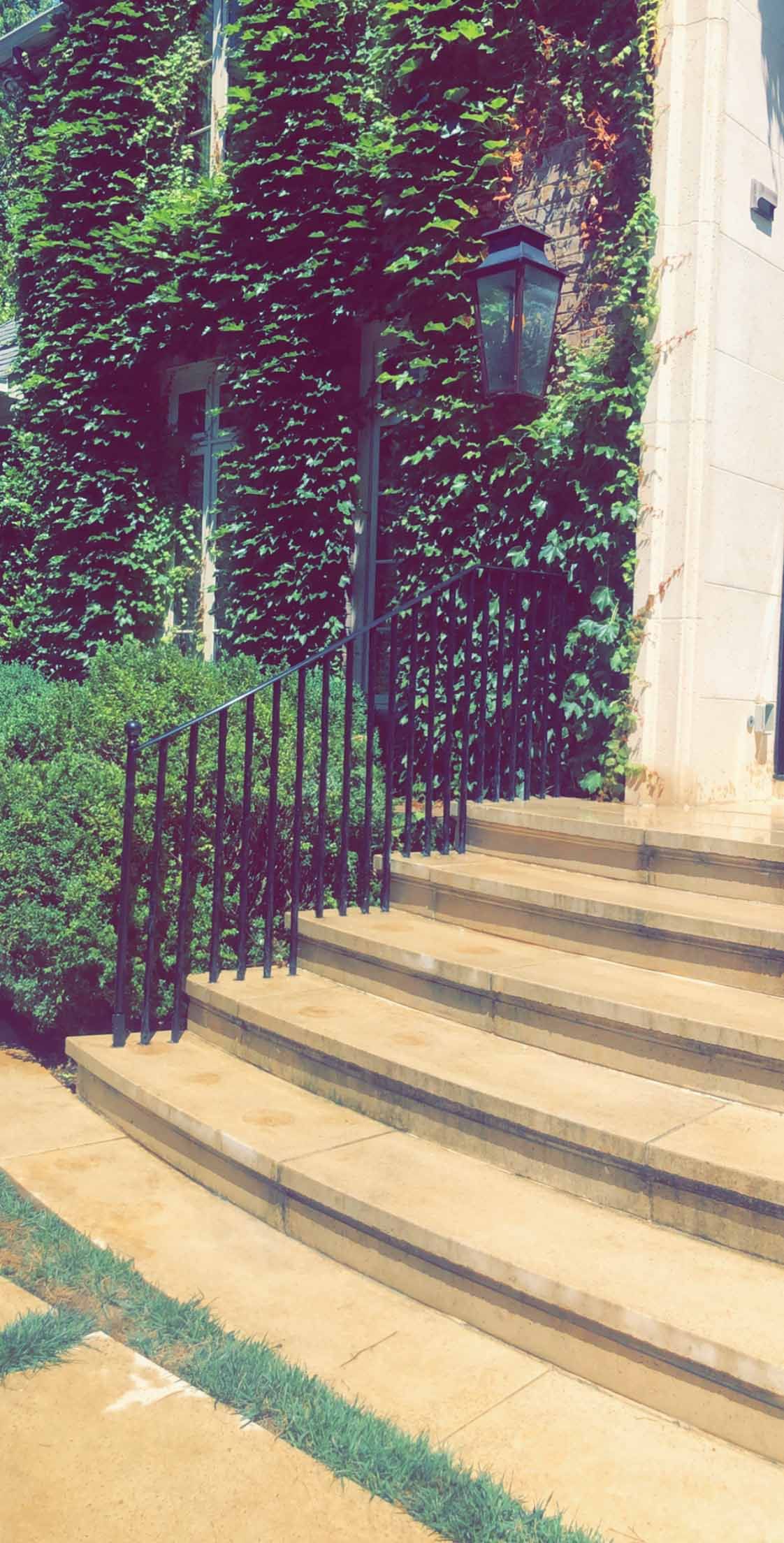 A set of stairs leading up to a building with a fence in front of it.
