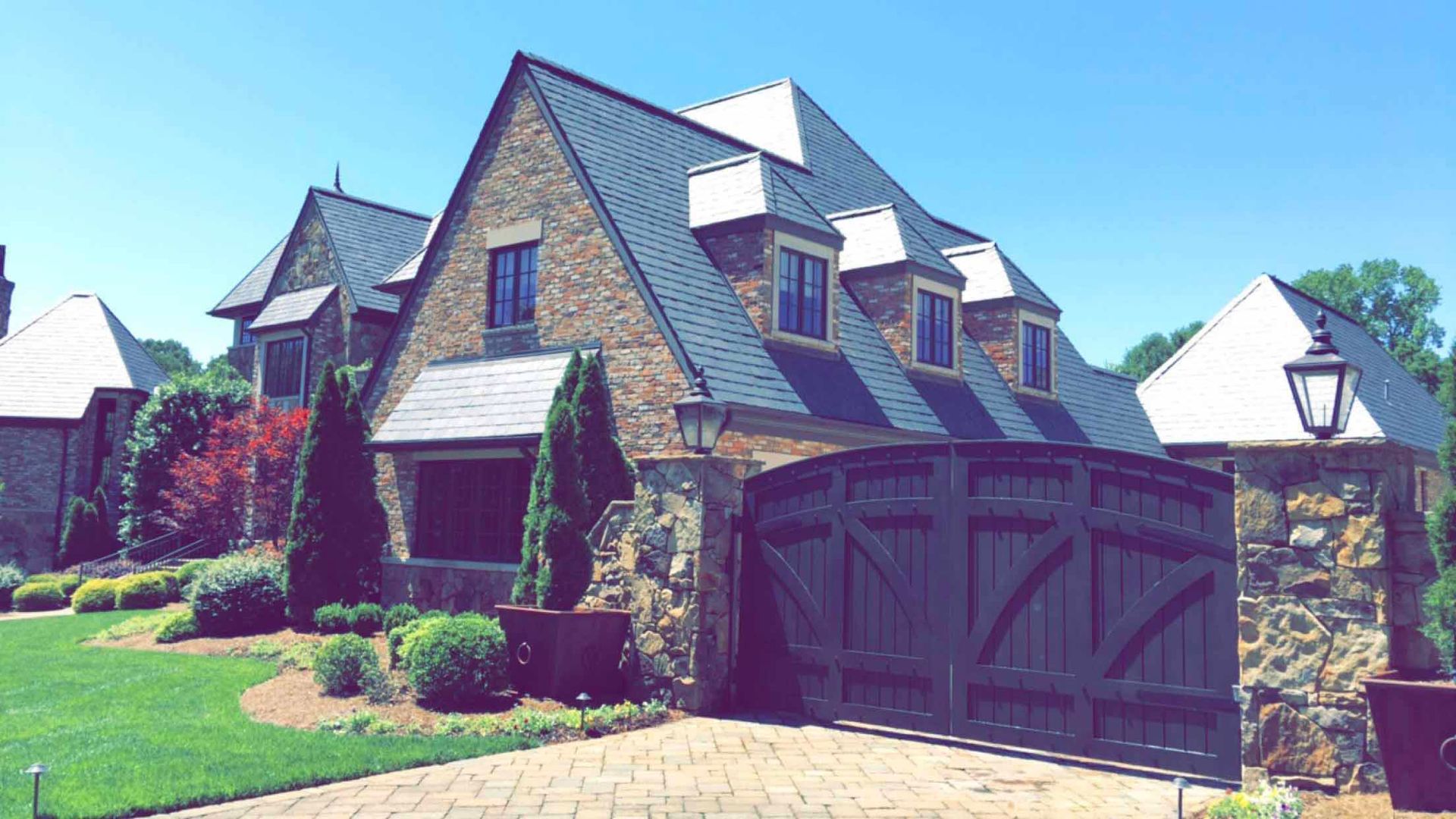 A large brick house with a wooden gate in front of it.