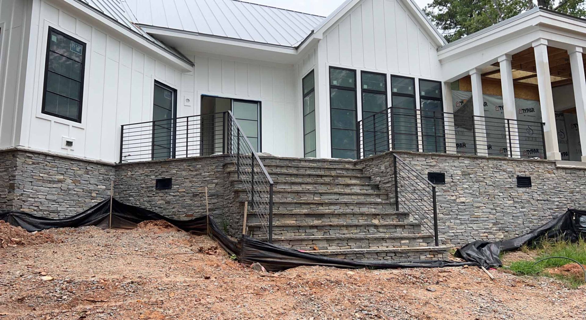 A large white house with stairs leading up to it is being built.