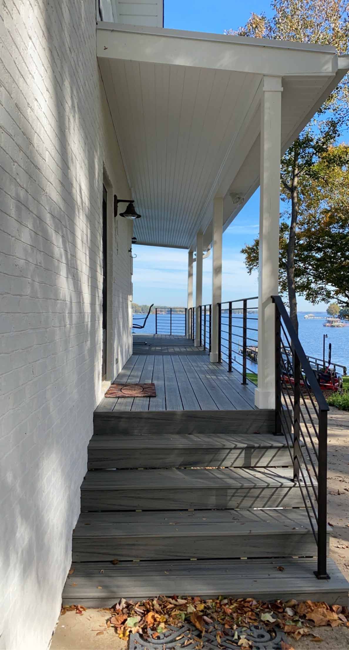 A white house with a porch and stairs leading to it.