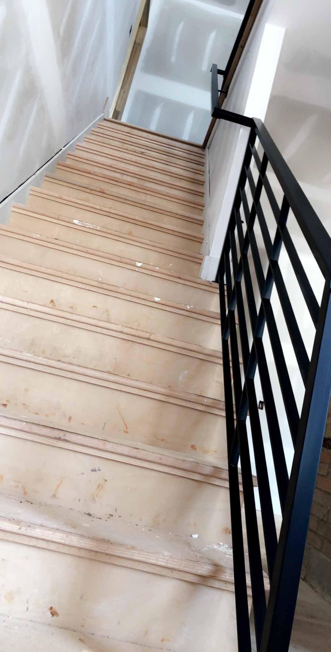 A close up of a staircase with a metal railing.