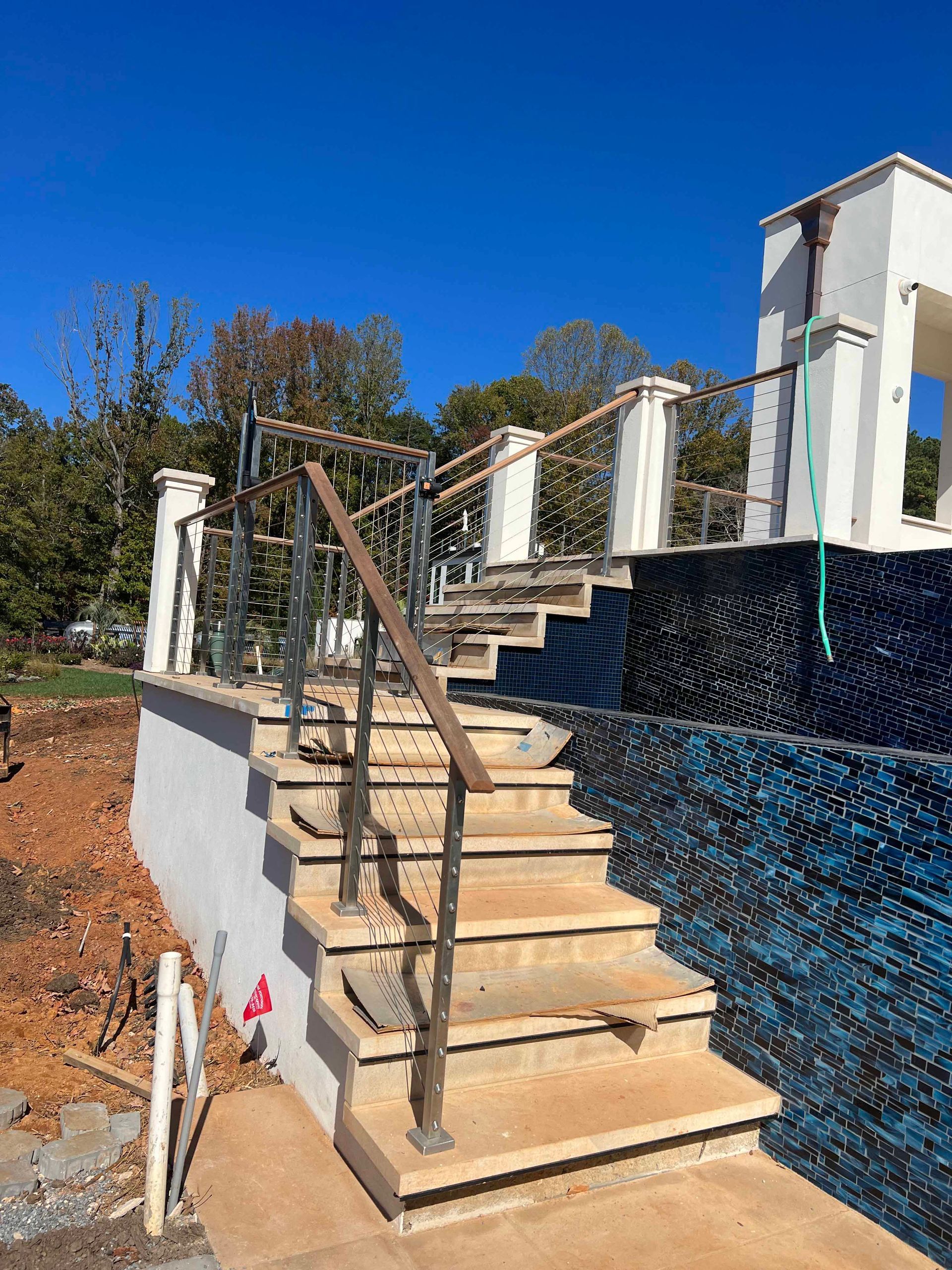 A set of stairs leading up to a swimming pool under construction.