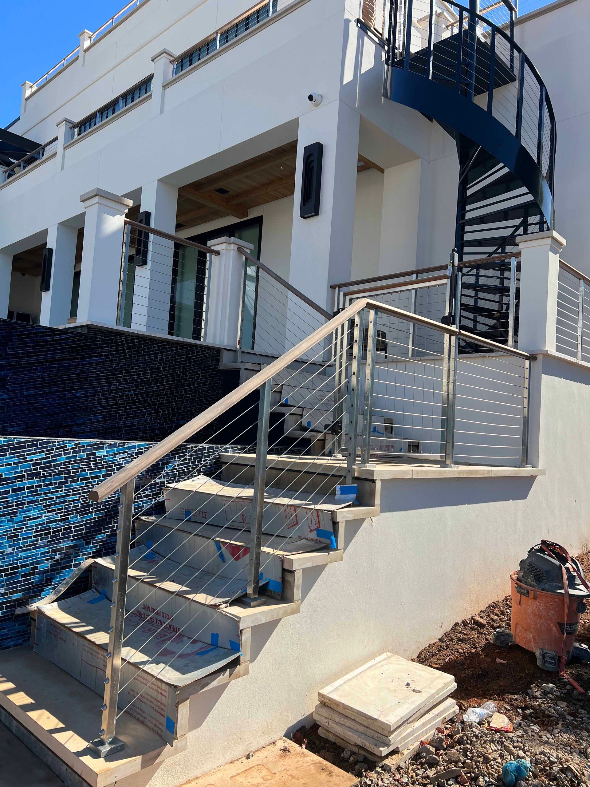 A spiral staircase is being built in front of a white building.