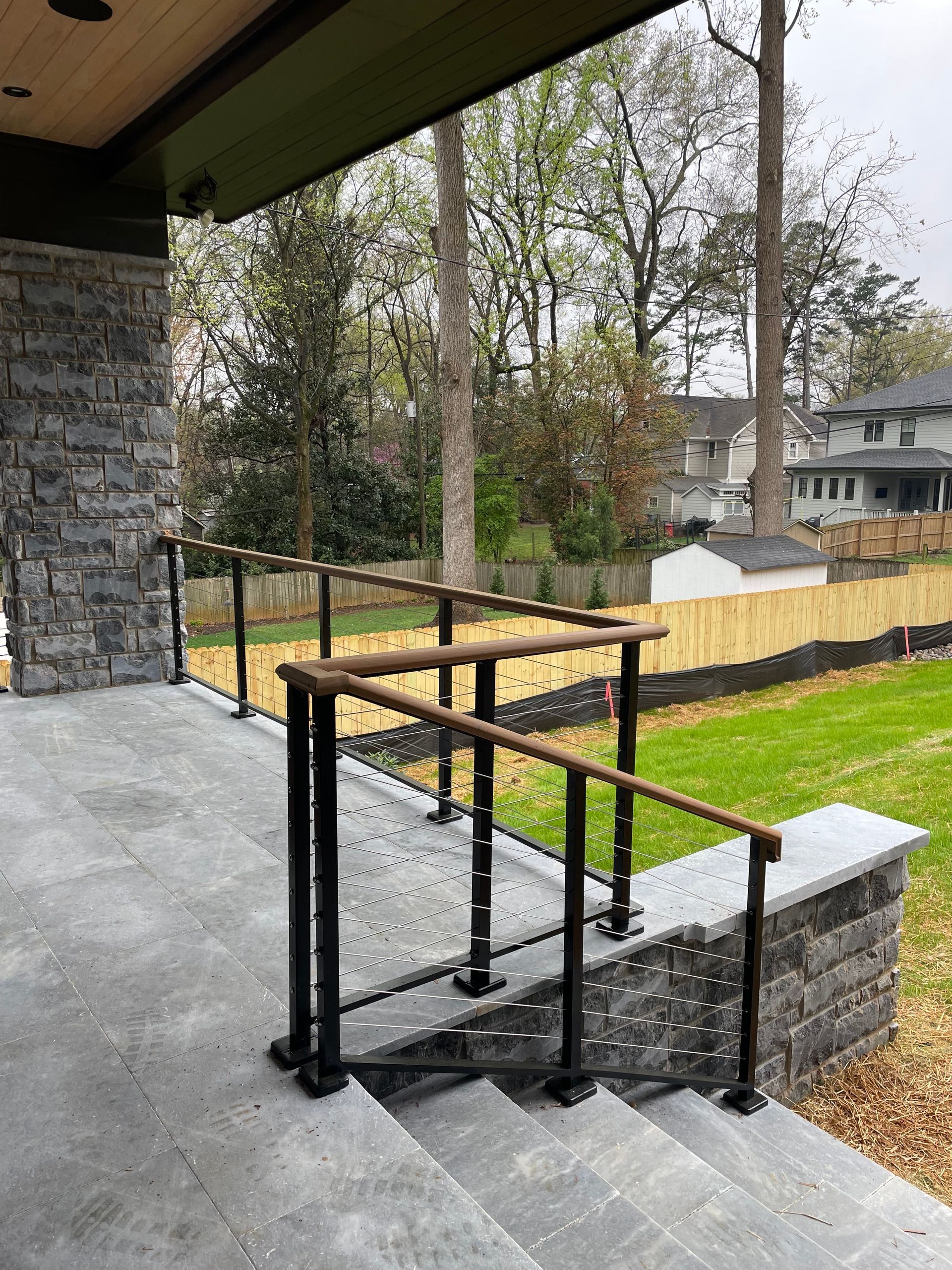 A staircase with a railing and a view of a yard.