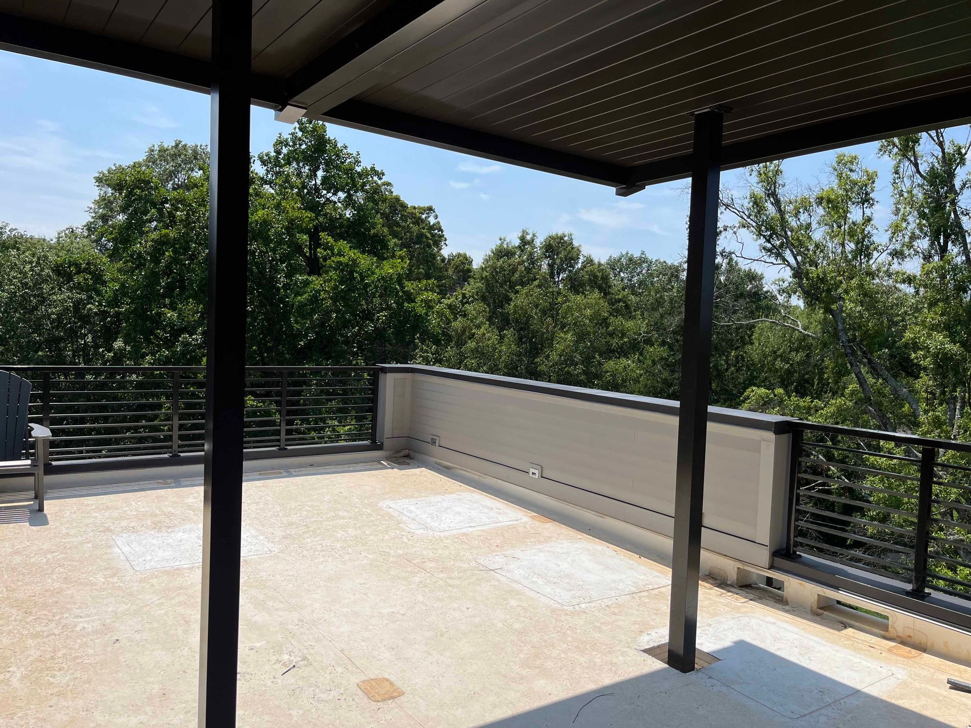 A rooftop deck with trees in the background