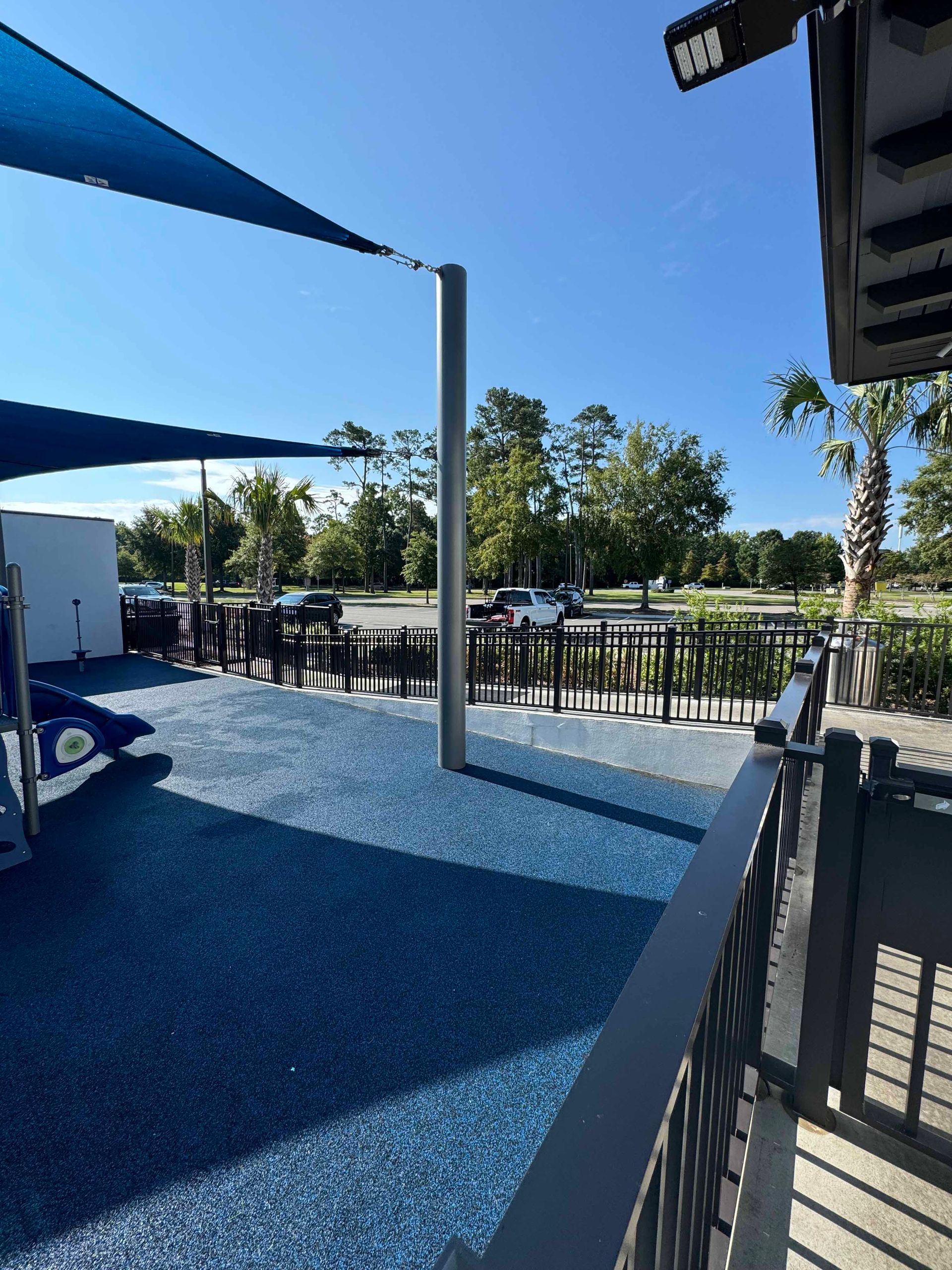 A view of a playground from a balcony on a sunny day.