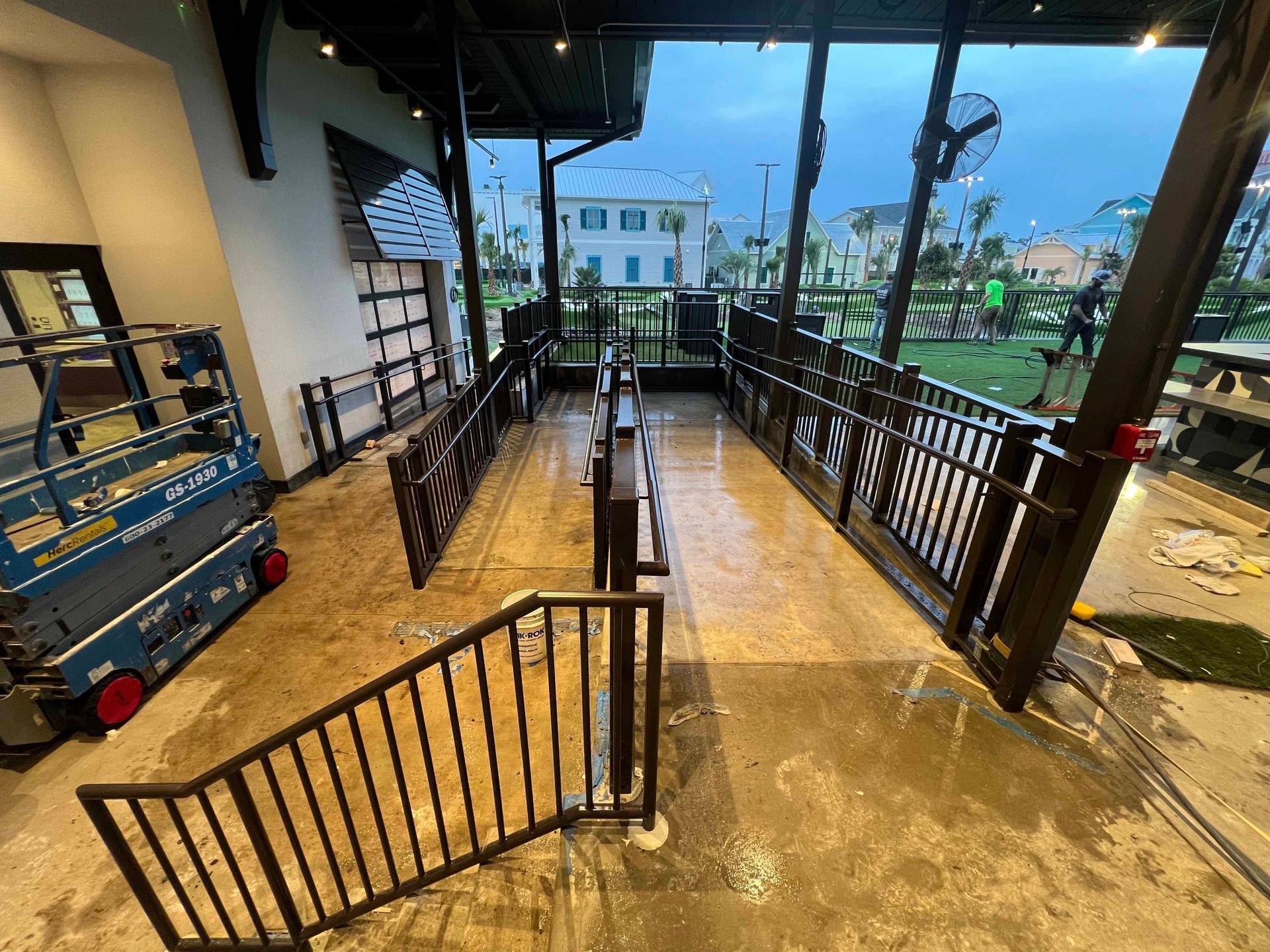 An empty room with a staircase leading to a balcony.